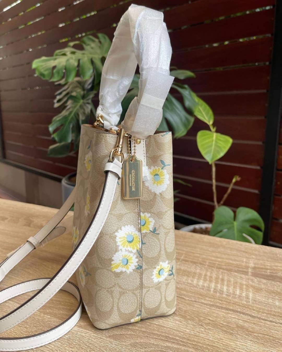 OUTLET 】COACH C3411 SMALL TOWN BUCKET BAG IN SIGNATURE CANVAS WITH DAISY PRINT สวยสดใสมาให้ถึงบ้านจ้า!! กระเป๋าทรงบัคเก็ตยอดฮิต รอบนี้น่ารักมุ้งมิ้งไม่เลิก ดีไซน์ลายดอกเดซี่คละรอบใบ วัสดุหนังแคนวาสเคลือบลาย ปากกระเป๋าเปิด-ปิดด้วยกระดุมแม่เหล็ก 2ฝั่ง มีหูจ