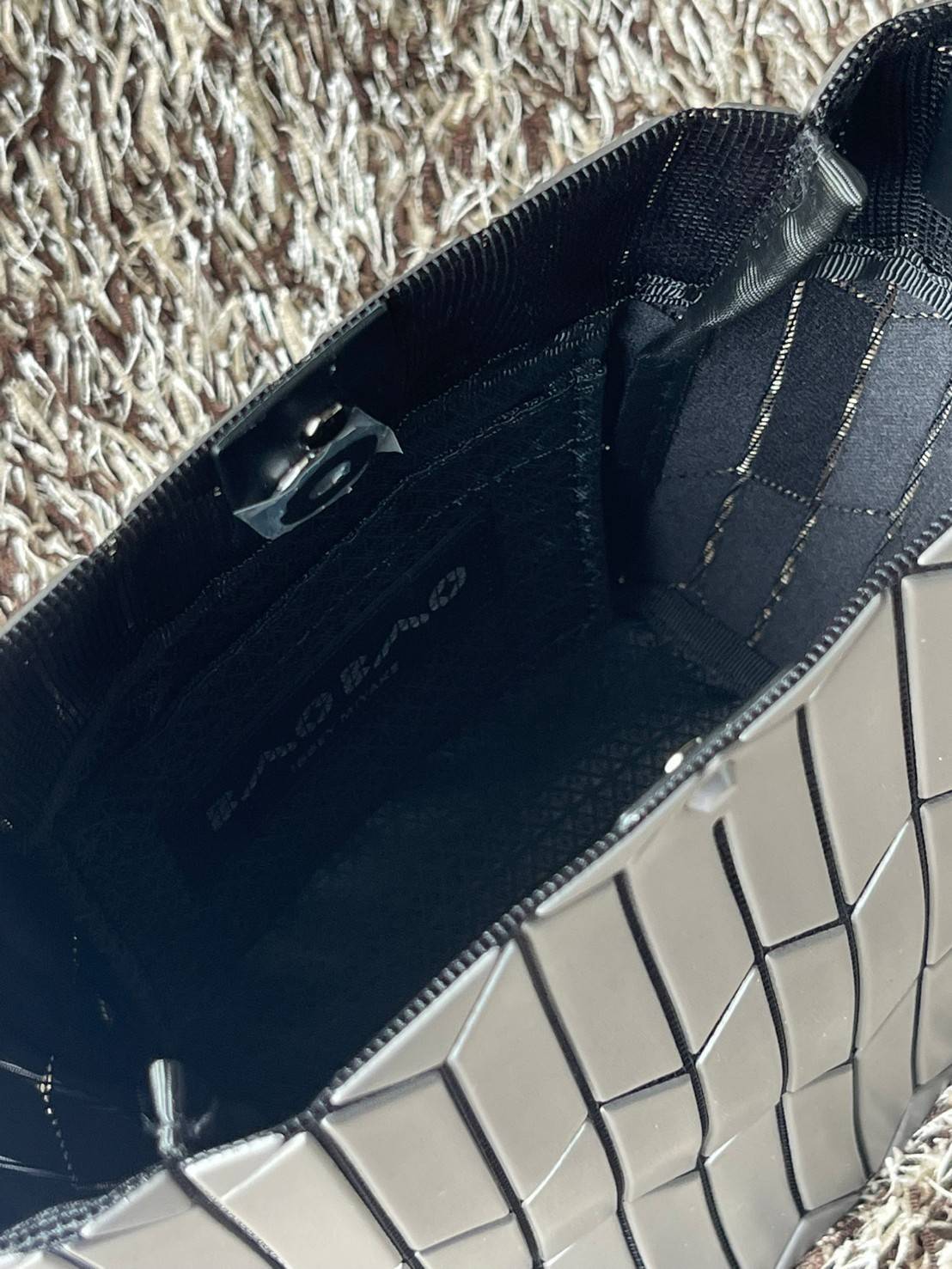 Small : BAO BAO ISSEY MIYAKE SMALL BUCKET เป็นกระเป๋าบัคเก็ตขนาดเล็กสามารถใช้ใส่กระเป๋าสตางค์และโทรศัพท์มือถือได้ ซีรีย์ใหม่นี้มีจุดเด่นที่แผ่นรูปทรงสี่เหลี่ยมด้านขนานในแนวตั้ง เกิดเป็นรูปทรงสามมิติซึ่งแตกต่างไปจากรูปทรงที่เกิดขึ้นจากแผ่นสามเหลี่ยม หูหิ้ว