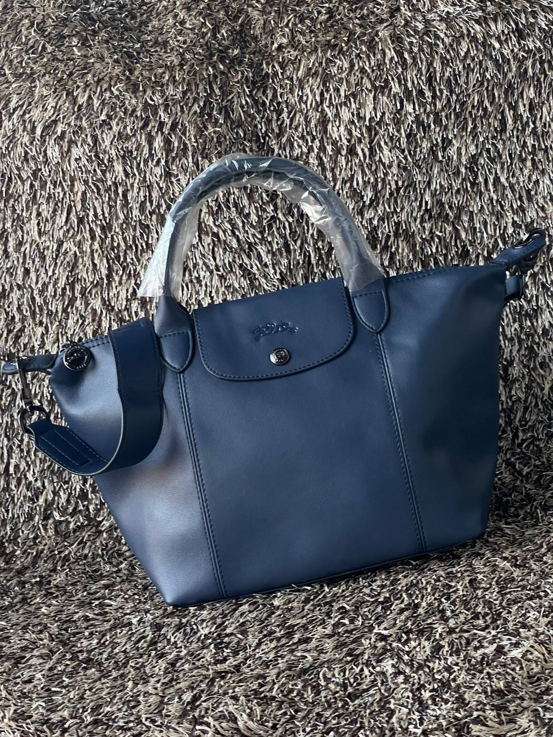 Longchamp Le Pliage Cuir Top handle bag S เรียกว่าเป็นกระเป๋าอีกหนึ่งรุ่นที่ไม่ว่ายังไงก็ฮอตฮิตและติดเทรนด์ตลอดไม่เคยเปลี่ยนกับ ทรง Le Pliage Cuir หนึ่งในตระกูลกระเป๋าสุดไอคอนิกจากแบรนด์