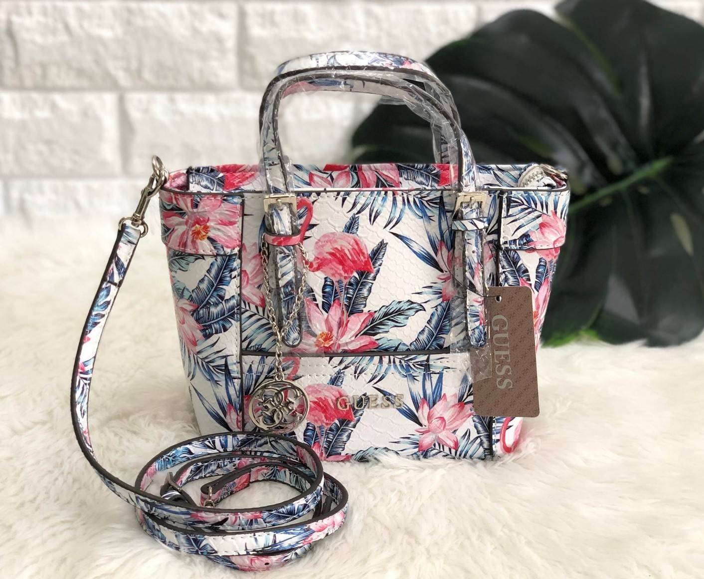 GUESS FLAMINGO MINI TOTE BAG ลายใหม่ล่าสุด กระเป๋าถือหรือสะพายข้าง ลาย flamingo ทั้งใบ สวยงามน่าใช้ ด้านหน้าห้อยพวงอะไหล่แบรนด์ เปิดปิดกระเป๋าด้วยซิป ภายในโล่ง ใส่กระเป๋าสตางค์ใบยาวได้ มีช่องซิปและช่องเล็ก มาพร้อมสายยาวถอดออกได้ เลื่อนปรับระดับได้ รุ่นนี้