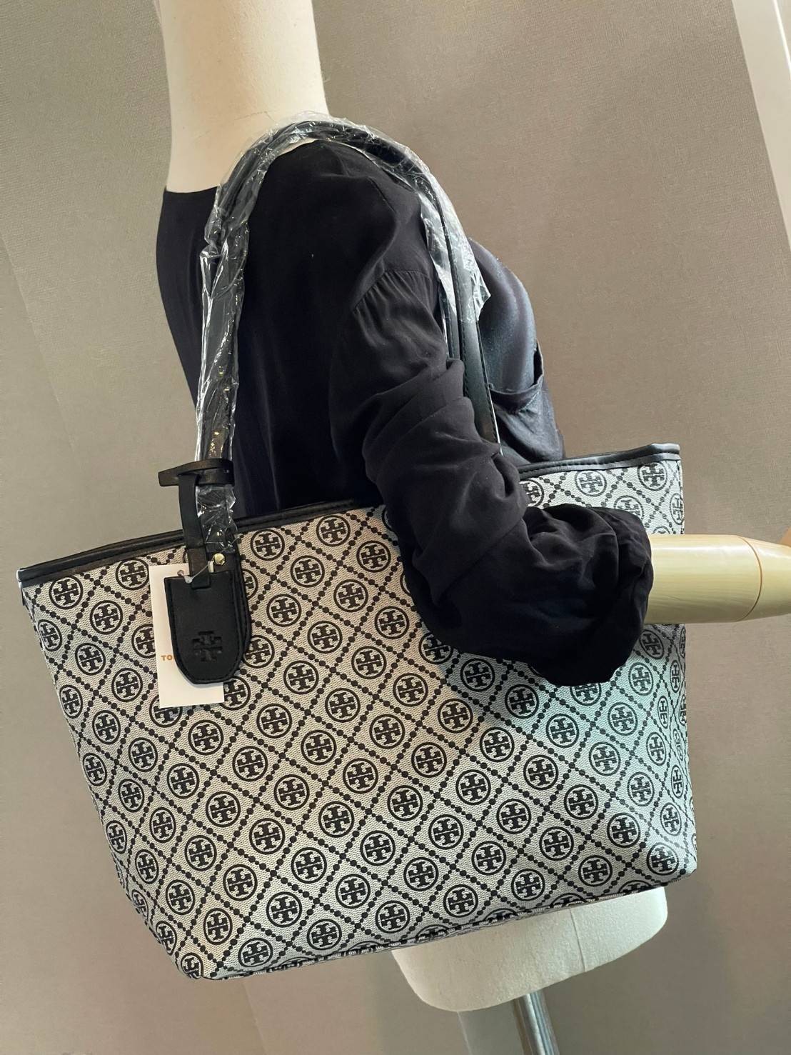 OUTLET 】Tory burch T Monograme Large shopping bag กระเป๋าสะพายใบไหล่ใบใหญ่ โดยตัวกระเป๋าทำมาจากผ้าแคนวาสเคลือบผิวด้านทนต่อรอยขีดข่วนได้เป็นอย่างดี ขนาดที่ใหญ่สามารถใส่ได้ทั้งเอกสารและสัมภาระต่างๆ พร้อมด้วยซิปปิดกระเป๋าด้านบนจึงเป็นอีกรุ่นที่เหมาะกับสาวออฟ