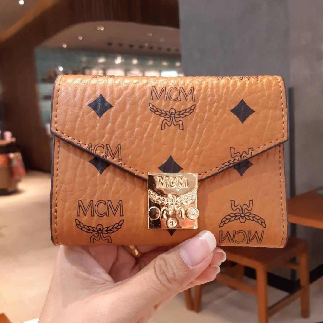 M.C.M PATRICIA THREE-FOLD WALLET IN VISETOS กระเป๋าสตางค์ใบเล็ก รุ่นฝาพับ unisex ใช้ได้ทั้งหนุ่มๆและสาวๆน้า ใช้งานง่าย ด้วยกระดุมโลโก้ พกพาง่าย วัสดุหนังแคนวาสคุณภาพดี ภายในเป็นหนังแท้ นิ่ม สวย ใส่บัตรได้เยอะ ใส่ธนบัตรได้ทุกชนิด ในช่องมีที่ใส่บัตรพิเศษภาย