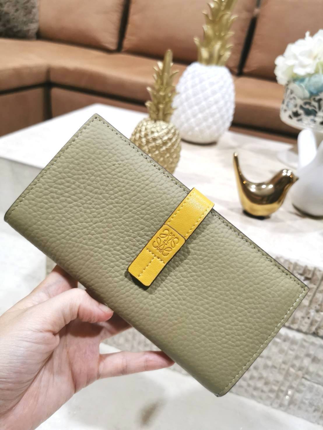 LOEWE LONG WALLET BAG วัสดุหนังแท้เทคเจอร์สวยอยู่ทรงปั้มโลโก้แบรนด์ด้านหน้าเปิดปิดด้วยกระดุม ภายในมีช่องใส่ธนบัตรหลายช่อง ช่องหลักสามารถใส่มือถือได้ มีช่องซิปใส่เหรียญ ช่องใส่ธนบัตรใส่แบงก์พันได้ สวยน่าใช้ พร้อมส่งที่ไทยสุดคุ้มห้ามพลาด!