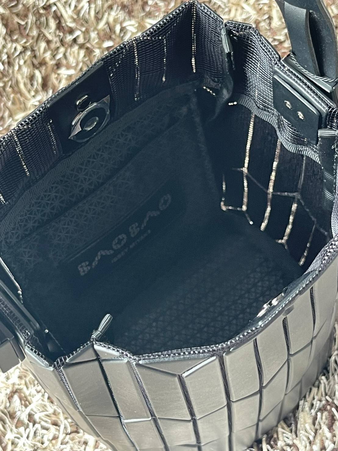 Small : BAO BAO ISSEY MIYAKE SMALL BUCKET เป็นกระเป๋าบัคเก็ตขนาดเล็กสามารถใช้ใส่กระเป๋าสตางค์และโทรศัพท์มือถือได้ ซีรีย์ใหม่นี้มีจุดเด่นที่แผ่นรูปทรงสี่เหลี่ยมด้านขนานในแนวตั้ง เกิดเป็นรูปทรงสามมิติซึ่งแตกต่างไปจากรูปทรงที่เกิดขึ้นจากแผ่นสามเหลี่ยม หูหิ้ว