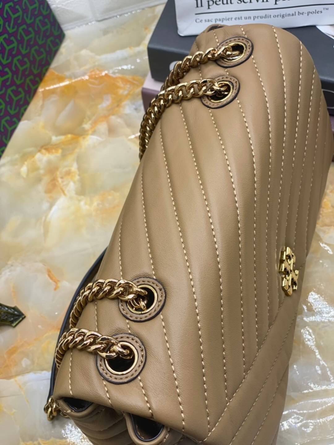 Large : Tory Burch Kira Chevron Quilted Convertible Leather Crossbody Bag เป็นกระเป๋าที่ใช้ในการออกงานสำคัญหรือวันที่มีปาร์ตี้สังสรรค์ คุณควรเลือกใช้กระเป๋าที่มีดีไซน์สะดุดตา เพราะจะช่วยยกระดับและเพิ่มเสน่ห์ให้กับตัวคุณเองมากยิ่งขึ้น หากเป็นงานทางการ เช่น