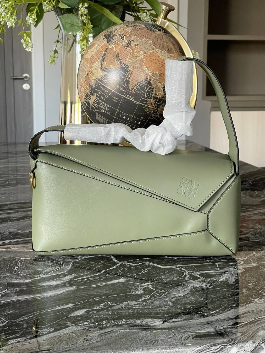 Loewe Puzzle Hobo bag กระเป๋ารุ่น Puzzle มีความพิเศษในหลายด้าน ไม่ว่าจะเป็นรูปทรงที่แปลกใหม่ มินิมอลด้วยโลโก้อนาแกรมแบบประทับ ดูหรู เป็นกระเป๋า Unisex ที่ไม่ว่าคุณจะเป็นผู้หญิงหรือผู้ชายก็ใช้งานได้ ลายกระเป๋าได้มาจากการนำหนังมาเย็บต่อกันทั้งหมด ถึงแม้ว่าข