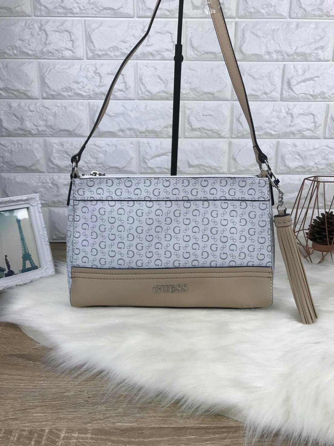 GUESS CROSSBODY BAG กระเป๋ารุ่นนิยม รุ่นนี้สวยเก๋มากๆ มีลายแบรนด์ตัดกับหนังเรียบสวยงาม พร้อมโลโก้แบรนด์สีเงินสวยเด้น มาพร้อมพวงกุญแจหนังเป็นพู่ๆ ประดับข้างๆ เปิดปิดด้วยซิปบน ด้านนายมีช่องใส่โทรศัพท์ และช่องอื่นๆ รุ่นนี้สามารถใส่กระเป๋าเงินใบยาวได้ ของจุกจ