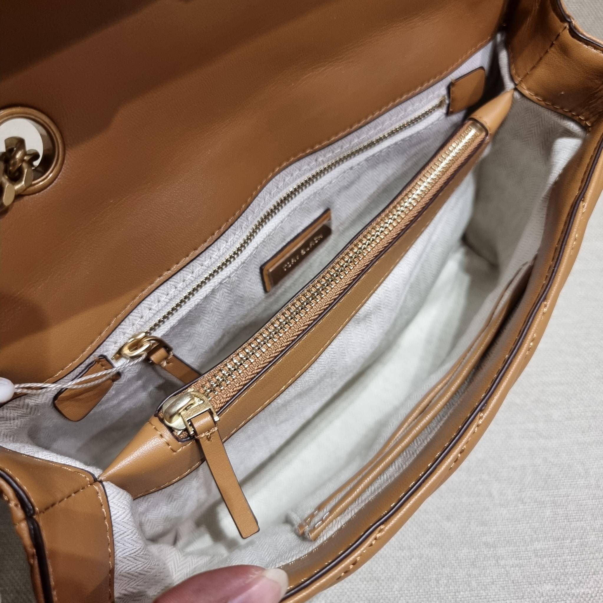 TORY BURCH KIRA CHEVRON CONVERTIBLE SHOULDER BAG กระเป๋าสะพายรุ่นยอดฮิต ไซส์ใหญ่จัดเต็มให้เน้นๆ ใช้ยังไงก็ดูหรู ดีไซน์เฉพาะตัว วัสดุหนังแกะ สัมผัสนิ่ม เปิด-ปิดด้วยกระดุมแม่เหล็ก ภายในเป็นช่องโล่ง แบ่งสัดส่วนไว้ดีมากๆ ใส่กระเป๋าสตางค์ มือถือ เครื่องสำอางค์