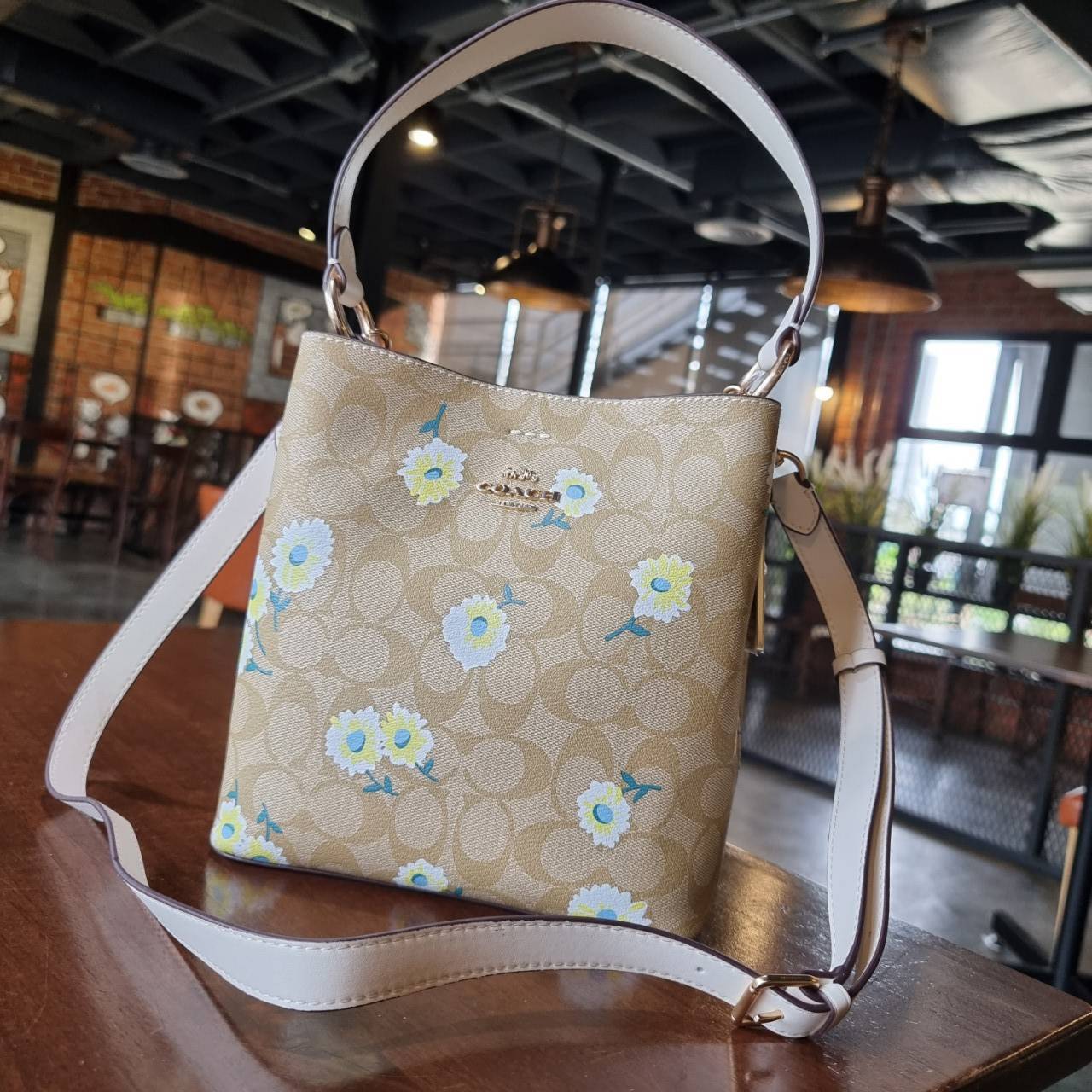 OUTLET 】COACH C3411 SMALL TOWN BUCKET BAG IN SIGNATURE CANVAS WITH DAISY PRINT สวยสดใสมาให้ถึงบ้านจ้า!! กระเป๋าทรงบัคเก็ตยอดฮิต รอบนี้น่ารักมุ้งมิ้งไม่เลิก ดีไซน์ลายดอกเดซี่คละรอบใบ วัสดุหนังแคนวาสเคลือบลาย ปากกระเป๋าเปิด-ปิดด้วยกระดุมแม่เหล็ก 2ฝั่ง มีหูจ