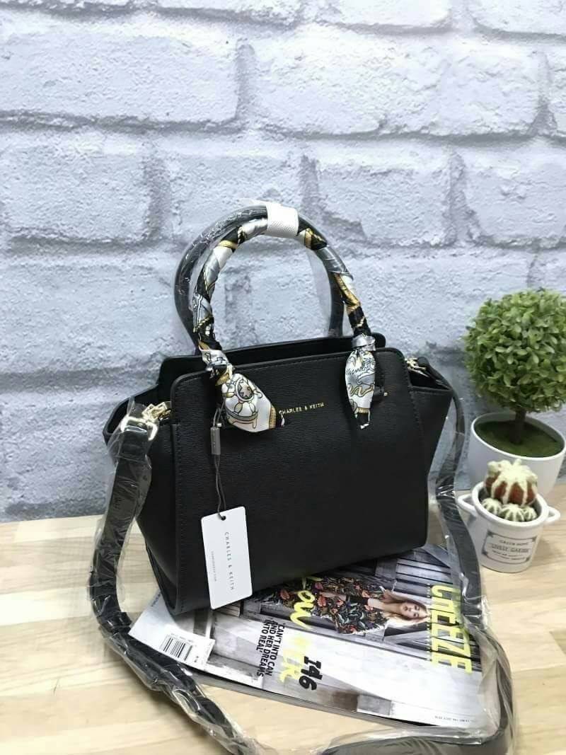 CHARLES&KEITH MINI TRAPEZ BAG พร้อมส่งรุ่นฮิตในตำนานรุ่นขายดี !! !กระเป๋าถือหรือสะพายหนังsaffiano พร้อมสายสะพายยาว115cmปรับความยาวได้5ระดับ ด้านล่างมีหมุดรองฐาน ทั้ง4มุม หูจับสูง14cmมีผ้าพันรอบสามารถถอดออกได้ ลายและสีสวยงามเข้ากับกระเป๋า ขนาดกำลังดีและน้ำ