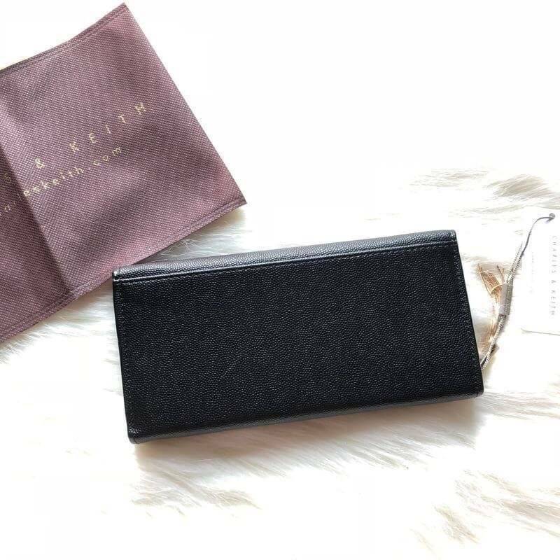 CHARLES & KEITH LONG WALLET กระเป๋าสตางค์ใบยาวแบบ 2 พับ หนังคาเวียร์ อะไหล่สีทอง และพู่สวยหรูมากค่ะด้านหน้าปั้มโลโก้แบรนด์ เปิดปิดด้วยฝาปิด ภายในมี1ช่องซิปแชะช่องเก็บบัตรหลายช่องใช้งานใส่ช่องใส่ธนบัตร แยกเป็นสัดส่วน ใบนี้สุดคุ้มเลยค่า