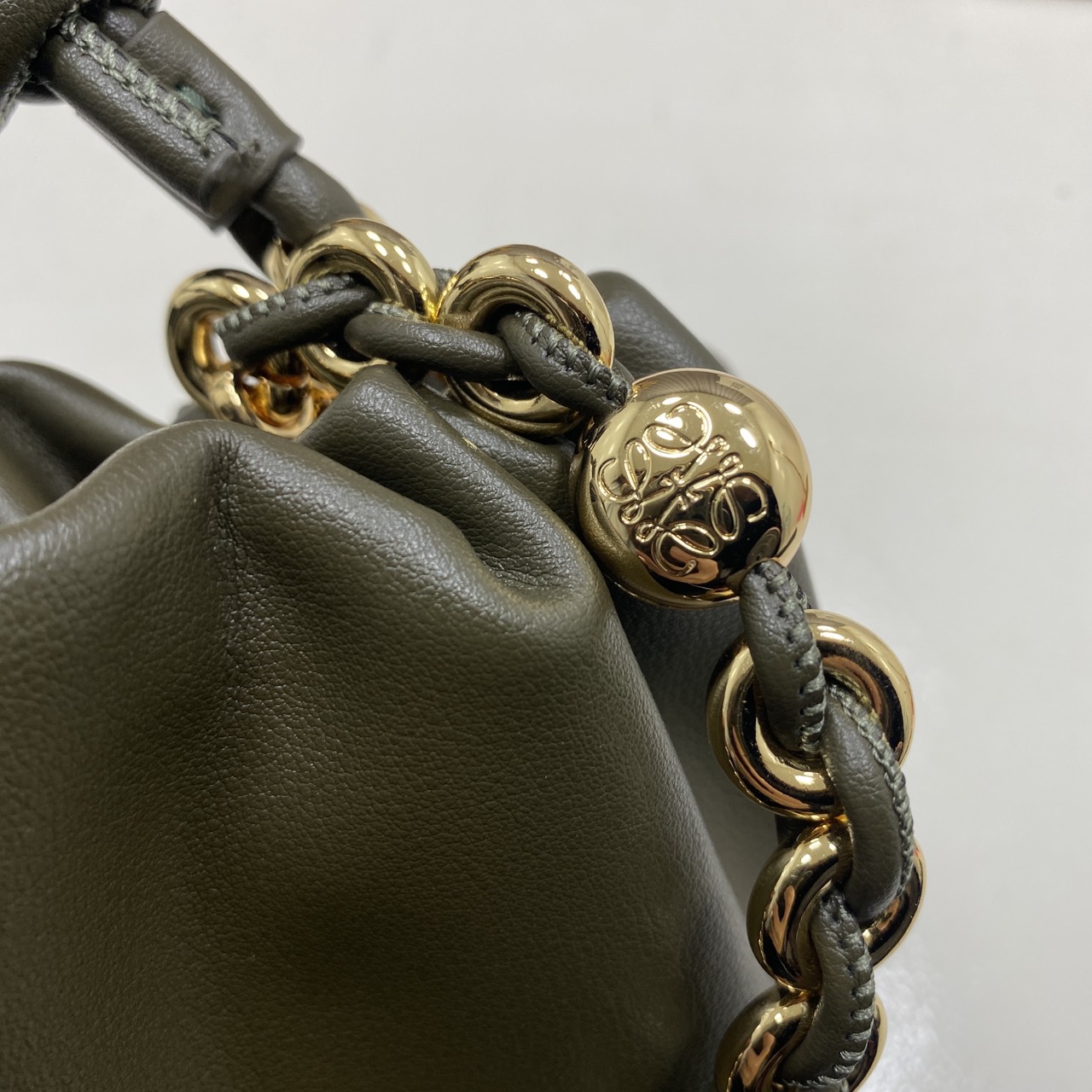 ORI หนังแท้ | LOEWE Mini Flamenco purse in mellow nappa leather / Loewe Bucket Bag กระเป๋าสะพายทรงบัคเก็ตไซส์มินิ หนังเรียบสวยหรู เรียบง่าย หนังแท้ผิวสัมผัสนุ่มมือ น้ำหนักเบาและนุ่มสบาย ดีไซน์จับจีบ เชือกผูกแบบปมโบราณ และสายโซ่รูปโดนัท