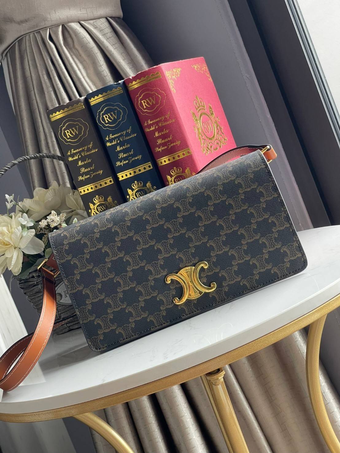 CELINE TRAPEZE TRIOMPHE BAG ดีไซน์เรียบหรู Timeless โดดเด่นมีเอกลักษณ์ ใช้ได้หลายโอกาส แมทช์กับการแต่งตัวง่าย จึงครองใจสาว ๆ ได้ไม่ยาก โดยเป็นกระเป๋าสะพายไหล่ที่อัดแน่นด้วยกลิ่นอายความคลาสสิกและหรูหราตามแบบฉบับของ Celine ด้านหน้าตกแต่งด้วยโลโก้สีทองโดดเด่