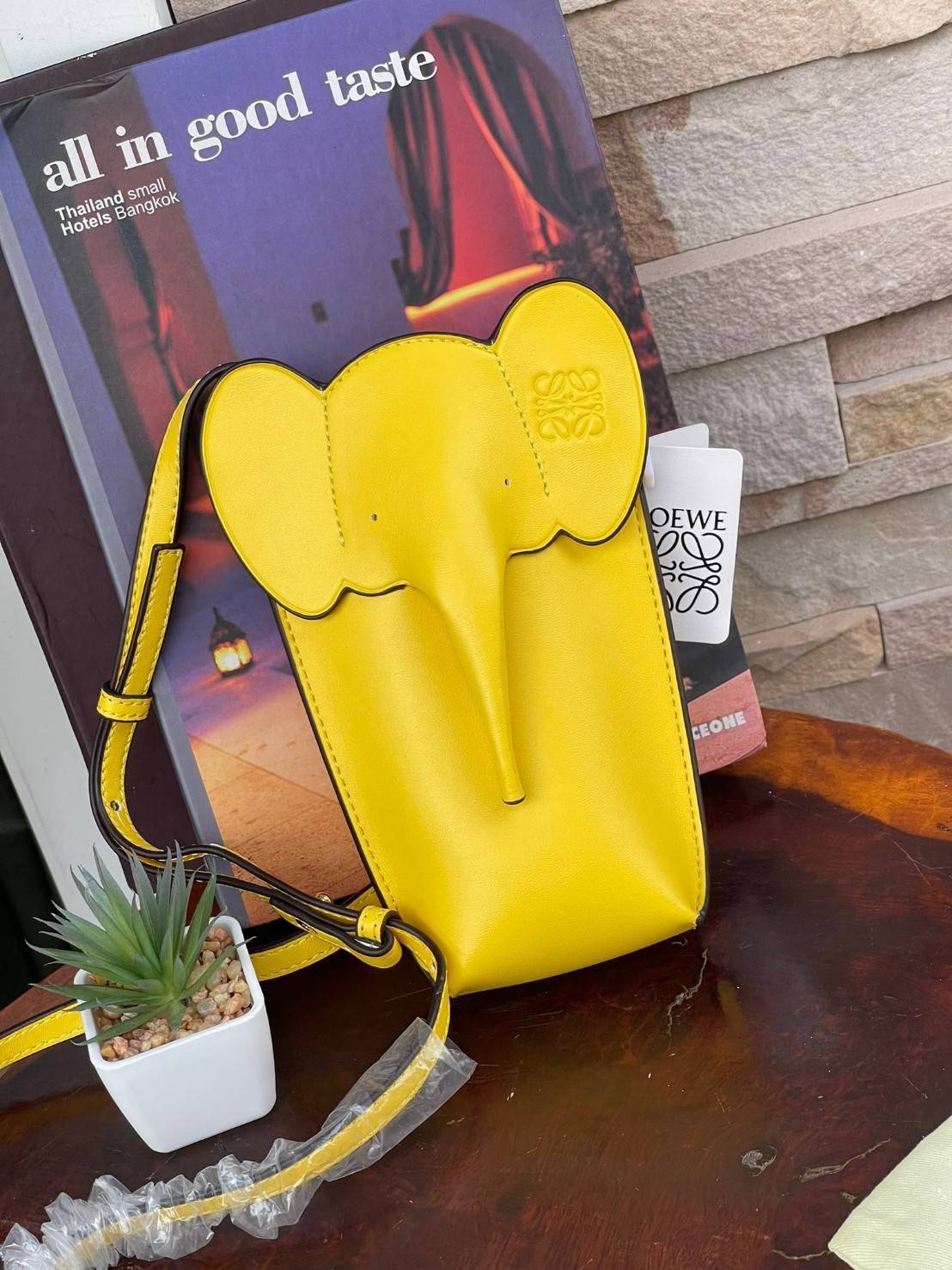 Loewe Leather Elephant Phone Holder แบรนด์หรูจากประเทศสเปนอย่าง โลเอเว่ (LOEWE) หลายๆคนคงนึกถึงกระเป๋ารูปทรงช้างขนาดเล็ก ที่เป็นเหมือนหนึ่งในซิกเนเจอร์ของแบรนด์ มีทั้งแบบสะพายข้าง แบบถือ รวมไปถึงในแบบเครื่องหนังชิ้นเล็กอย่างกระเป๋าใส่มือถือรุ่นนี้ ผลิตจาก