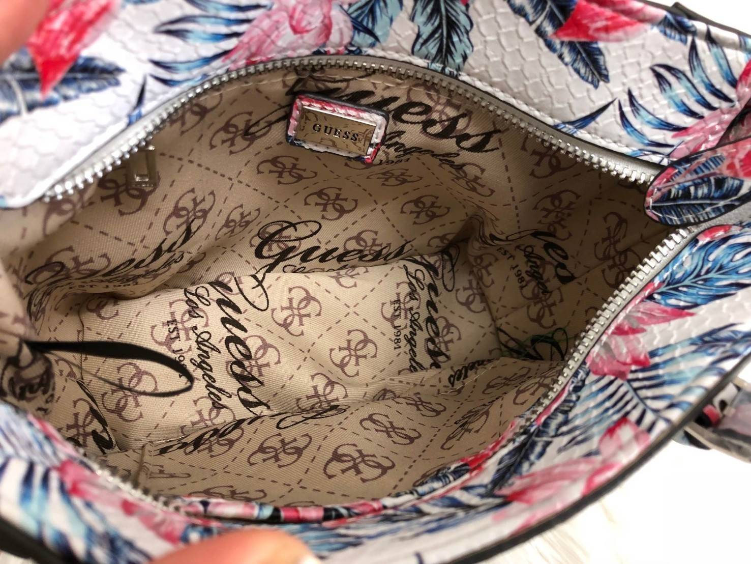 GUESS FLAMINGO MINI TOTE BAG ลายใหม่ล่าสุด กระเป๋าถือหรือสะพายข้าง ลาย flamingo ทั้งใบ สวยงามน่าใช้ ด้านหน้าห้อยพวงอะไหล่แบรนด์ เปิดปิดกระเป๋าด้วยซิป ภายในโล่ง ใส่กระเป๋าสตางค์ใบยาวได้ มีช่องซิปและช่องเล็ก มาพร้อมสายยาวถอดออกได้ เลื่อนปรับระดับได้ รุ่นนี้