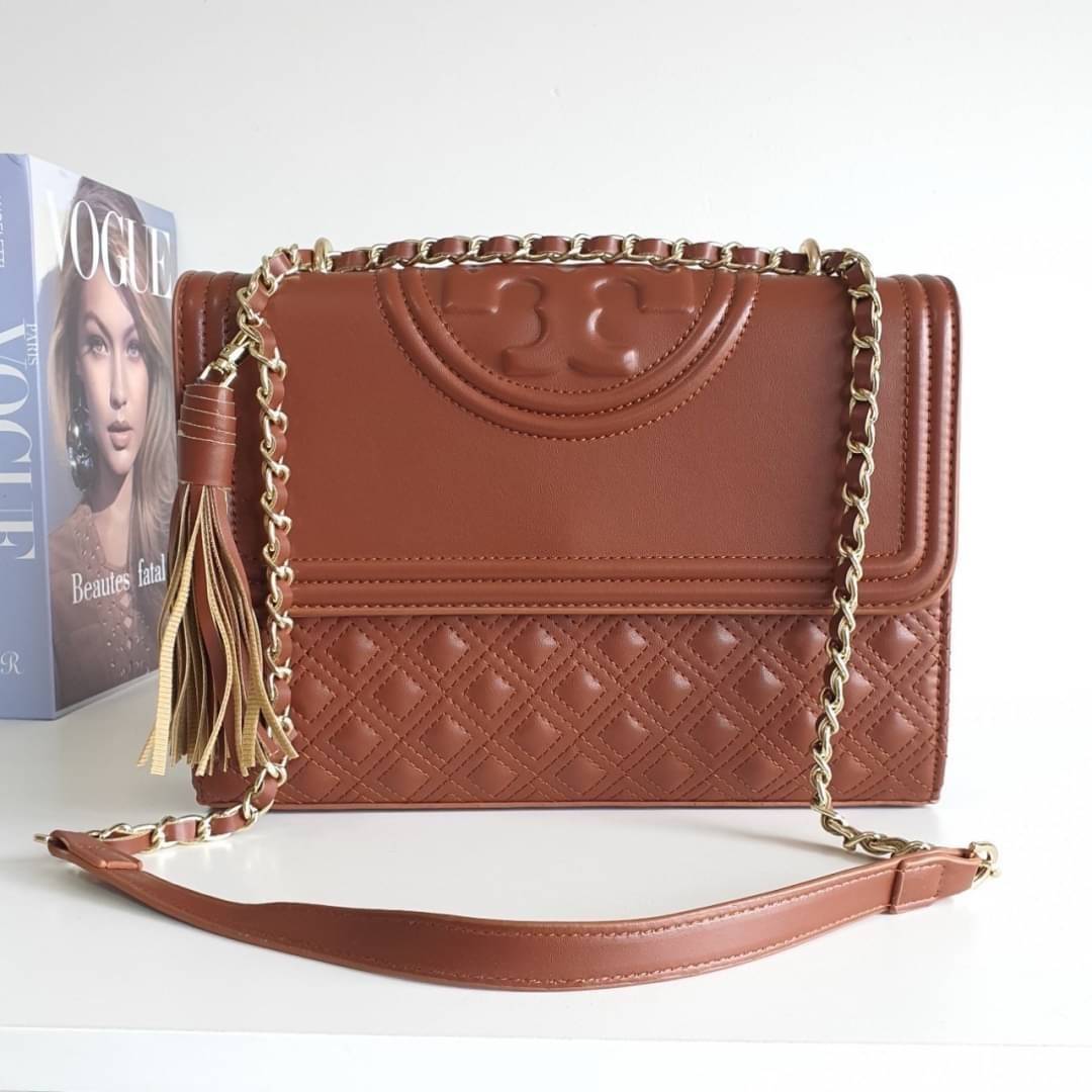 TORY BURCH Fleming Small Convertible Shoulder Bag รุ่นขายดีที่สุดกับ ไอเท็มที่ต้องมีแบรนด์ TORY BURCH มีมาให้ช้อปอีกแล้วค่ะสาวๆ กับทรง CLUCTH & CROSSBODY กระเป๋าสะพายข้างหรือสะพายเป็นครอสบอดี้ ประดับพู่ด้านข้าง