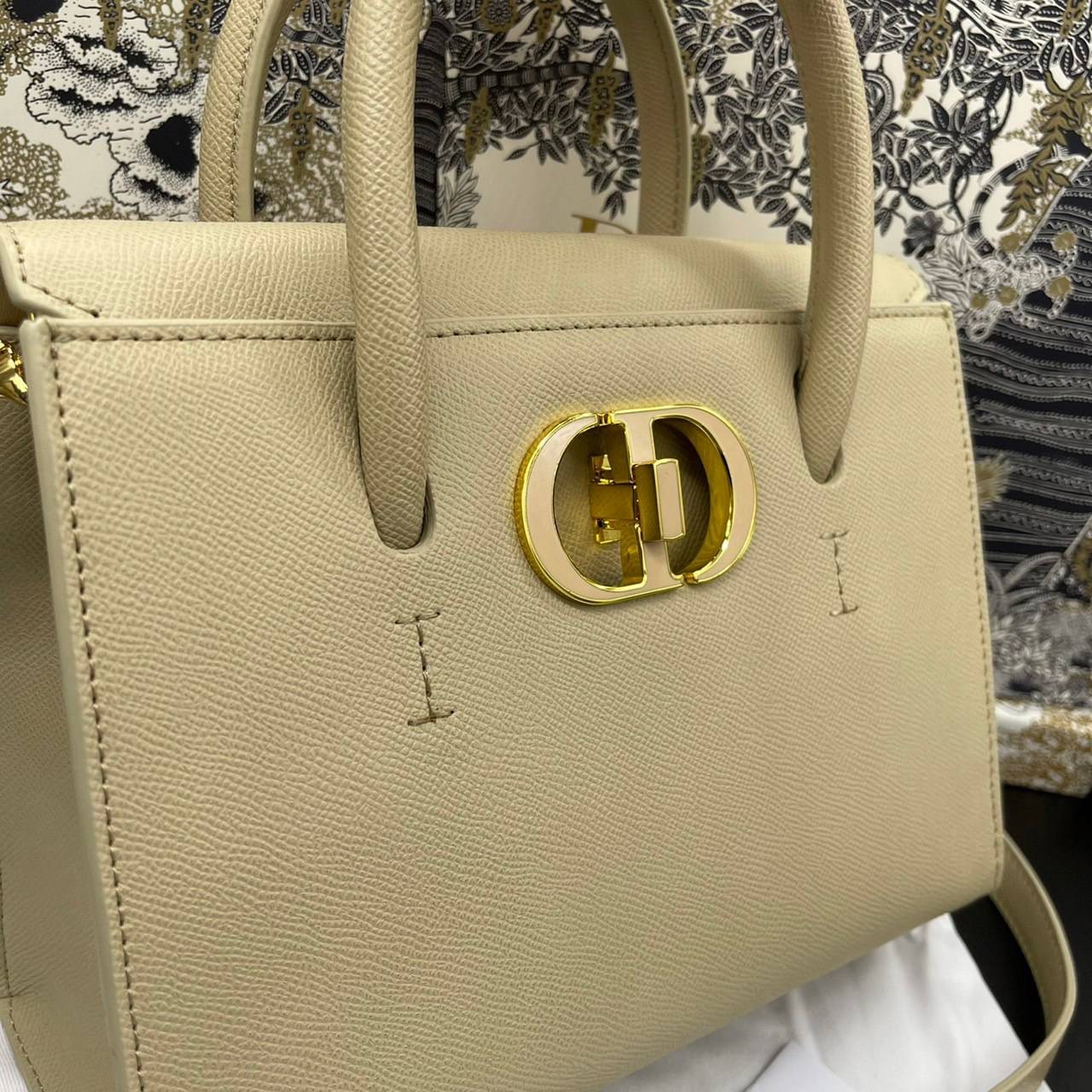 หนังแท้ DIOR Medium ST Honore Tote Collection Fall/Winter 2020-2021 มาในรูปแบบกระเป๋าทรงสี่เหลี่ยมที่ได้มาตรฐาน ทำจากหนังลูกวัว (Calfskin) ลายเกรน ซึ่งสื่อถึงความหรูหราได้อย่างลงตัว ตัวด้ามจับ มีการเย็บเข้าด้านในของกระเป๋าเพื่อเพิ่มความแข็งแรงทนทาน ด้านหน