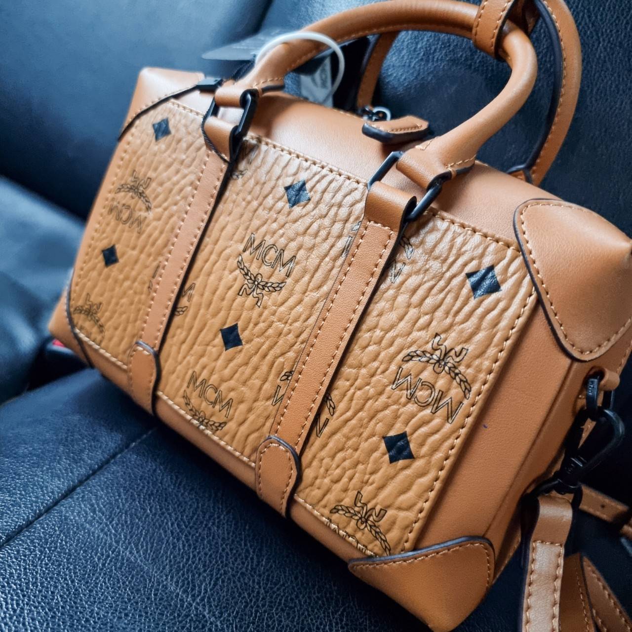 M.C.M SMALL E/W SOFT BERLIN CROSSBODY IN VISETOS ไอเท็มใหม่ในดีไซน์ทรงกระเป๋าเดินทางแบบคลาสสิค ย่อส่วนมาให้ใช้งานได้แบบสบายๆ พกพาสะดวก แมทช์ได้ทุกสไตล์ ใช้ได้แบบ unisex ใช้งานง่ายด้วยหูจับในตัว และซิปหลัก อะไหล่สีดำดูมีมิติตัดกับสีน้ำตาลคอนยัคได้เป็นอย่าง