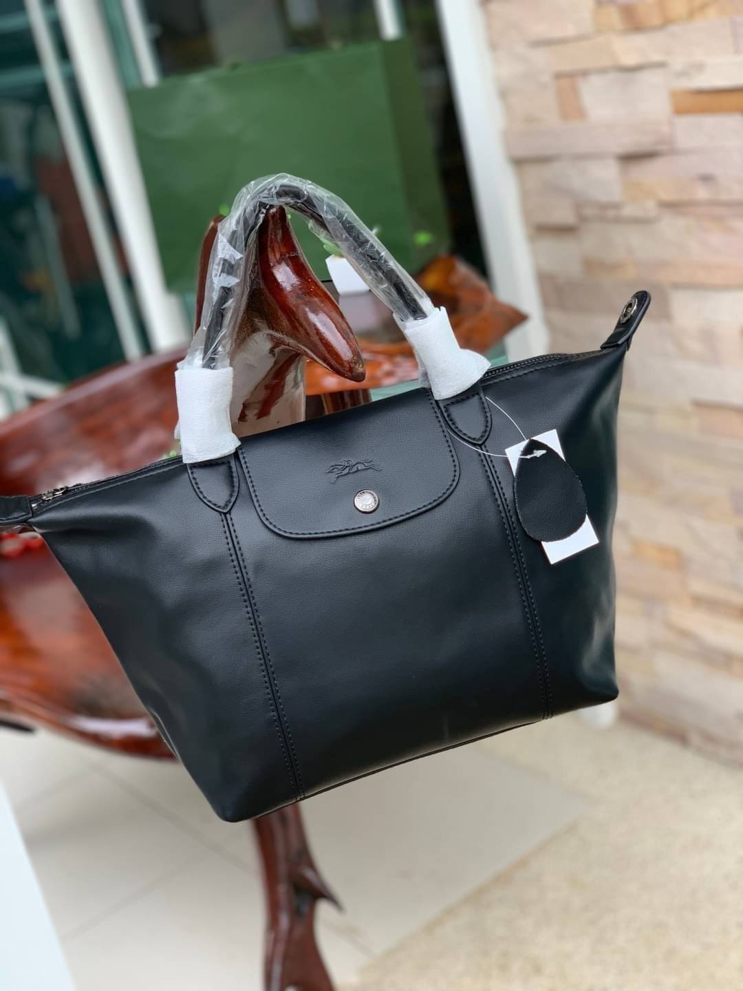 Longchamp LE PLIAGE CUIR TOP HANDLE BAG S เรียกว่าเป็นกระเป๋าอีกหนึ่งรุ่นที่ไม่ว่ายังไงก็ฮอตฮิตและติดเทรนด์ตลอดไม่เคยเปลี่ยนกับ ทรง Le Pliage Cuir หนึ่งในตระกูลกระเป๋าสุดไอคอนิกจากแบรนด์ เมื่อรุ่น Le Pliage Cuir ในรูปแบบของหนังแกะ Metis ได้ถือกำเนิดขึ้นใน