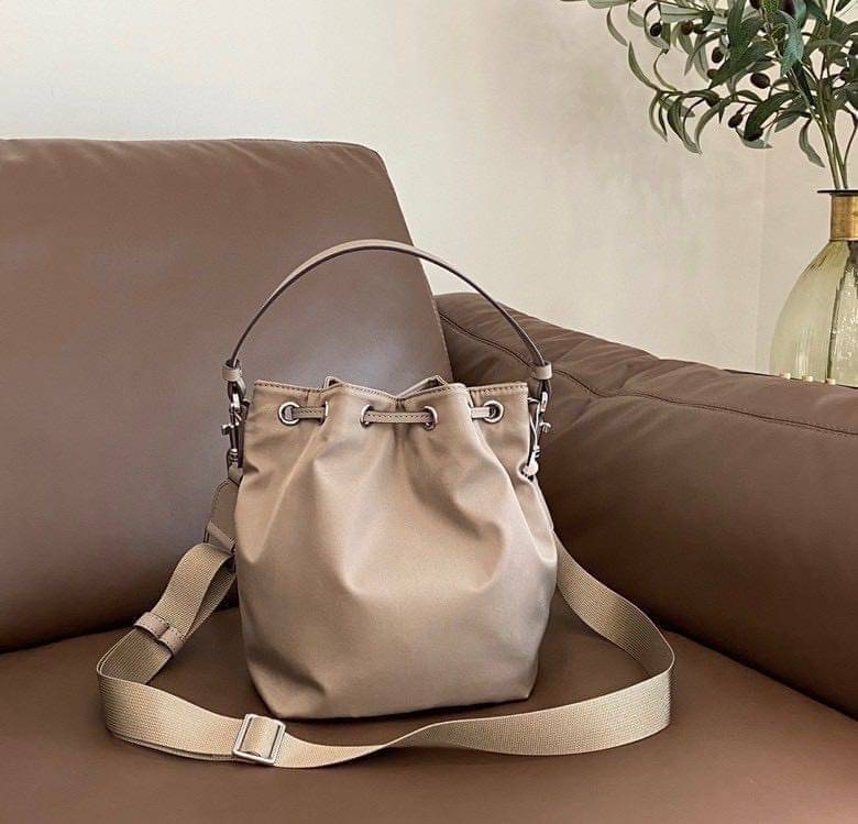 Tory Burch Virginia Nylon Bucket Bag / Tory Burch logo-plaque bucket bag กระเป๋าสะพายทรงบัคเก็ต เปิด-ปิดหนังรูดปากกระเป๋า มีหูหิ้วในตัว คล้องแขนเก๋ๆ ภายในเป็นช่องโล่ง มีช่องย่อย ใส่ของสำคัญจุกจิกได้ มีสายครอส จะสะพายไปไหนก็ได้ทุกโอกาส สวยเลิศทุกสี พร้อมส่