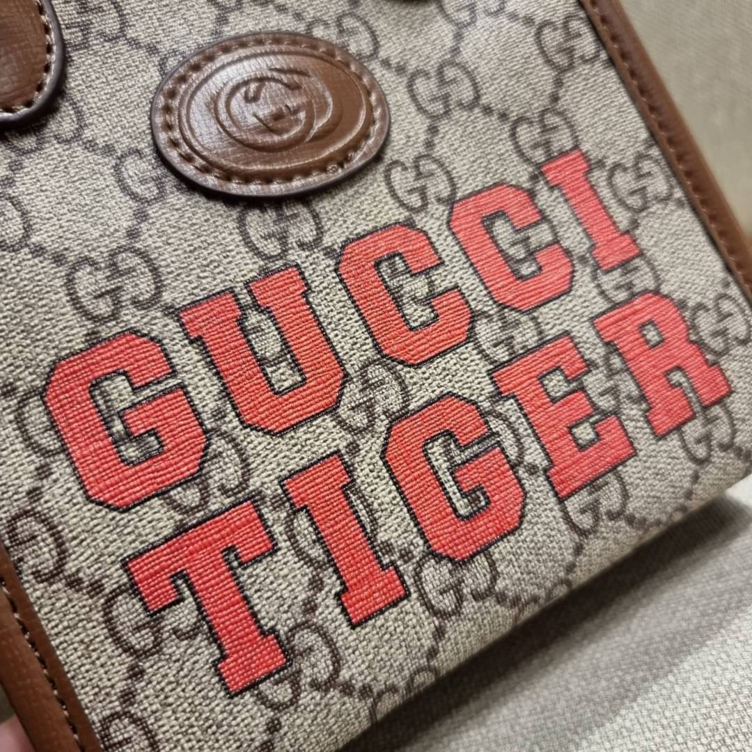 GUCCI Tiger GG mini tote bag ไซส์มินิ ร้อนแรงไฟลุก!! ต้อนรับปีเสืออย่างเป็นทางการ จัดให้แบบเลิศๆ กับกระเป๋าทรงโท้ท วีไอพีพรีเมี่ยมกิ๊ฟ ไซส์มินิ โดดเด่นด้วยฟอนท์ตัวใหญ่ สวยเอกลักษณ์ วัสดุหนังแคนวาสตัดขอบด้วยหนังแท้ ภายในเป็นช่องโล่ง ใส่ของจุกจิกได้ ใส่โทรศ