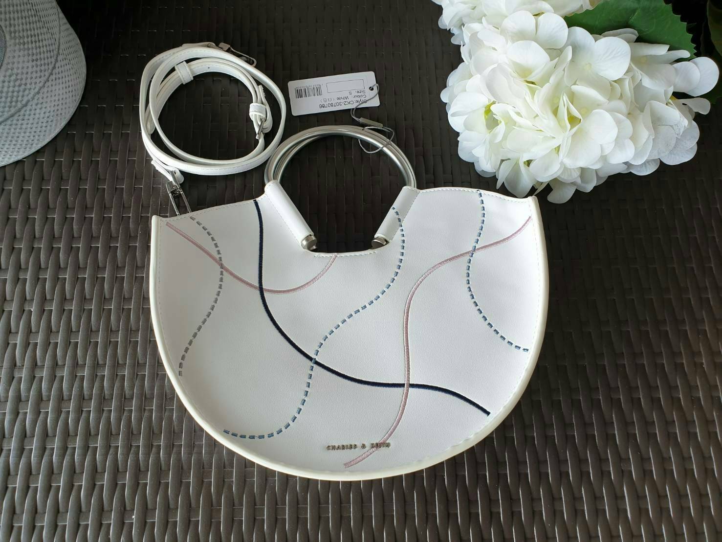 CHARLES & KEITH รุ่น U SHAPE TOP HANDLE BAG CK2-30780786_WHITE ราคาปกติช้อป ( ฿2,590.00 ) กระเป๋าทรงโค้งรูปตัว U วัสดุหนัง PU ลงแพทเทิร์นลวดลาย เส้นด้ายปักแต่งสีสัน บนตัวกระเป๋า เพิ่มความสวยสะดุดตา รับประกันความเก๋!! จะทำให้คุณโดดเด่นไม่เหมือนใคร หูกระเป๋