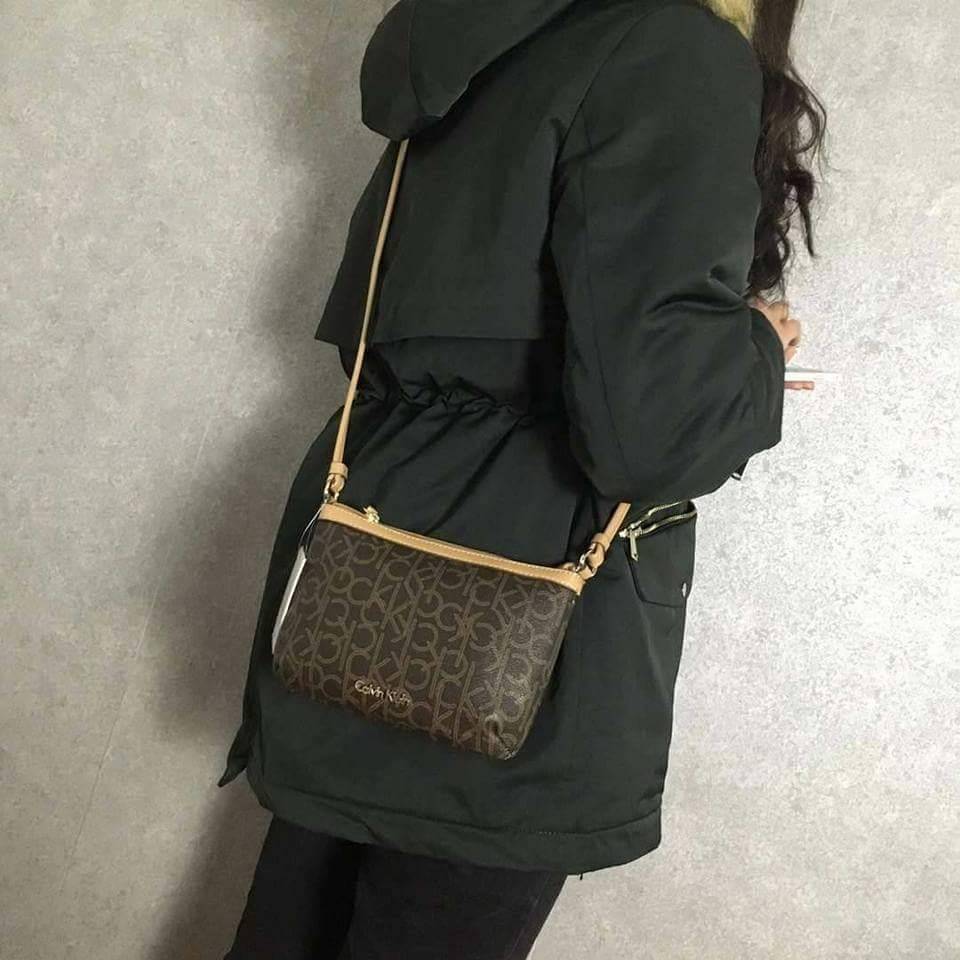 Calvin Klein Cross Body Bag กระเป๋าสะพายรุ่นใหม่ล่าสุดหนังสวย สกรีนลาย Signature แบรนด์รอบใบ ประดับโลโก้แบรนด์ สีทองด้านหน้า เปิดปิดด้วยซิป น้ำหนักเบา ภายใน โล่งกว้าง มีช่องใส่บัตร และช่องซิป ใส่ iphone+ ได้ มาพร้อมสายสะพายยาว ขนาดกำลังน่ารัก สะพายคล่องตั