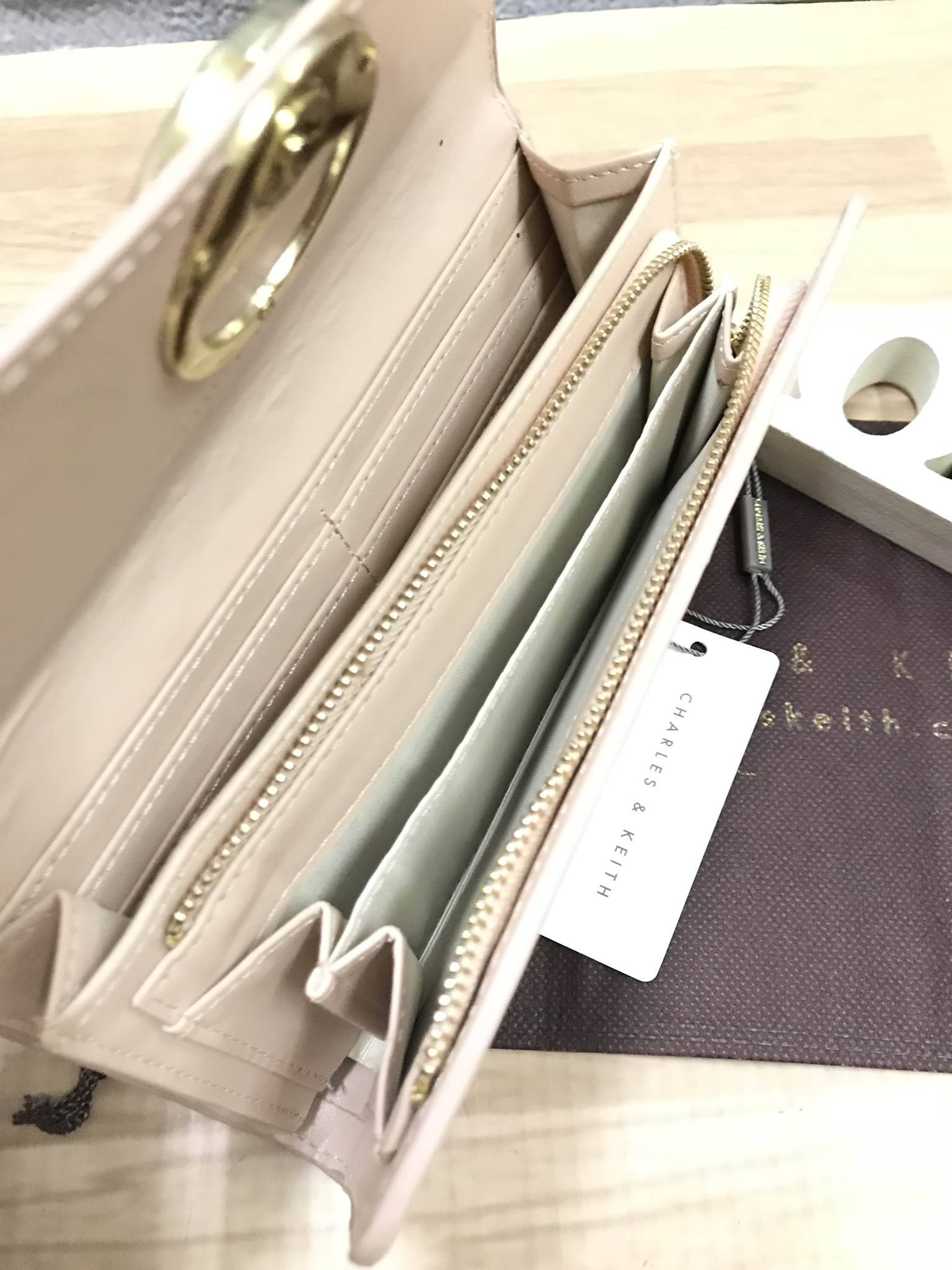 CHARLES & KEITH CIRCULAR DETAIL WALLET กระเป๋าสตางค์ทรงยาว วัสดุหนังpuที่มีทั้งแบบหนังเรียบและหนังลายคาร์เวียร์ เปิดปิดด้วยกระดุมแม่เหล็ก ภายในแยกเป็นช่องใส่บัตร,ธนบัตรและช่องซิปใส่เหรียญ ด้านหลังมีช่องใส่ของอีก1ช่อง ด้านหน้าดีไซน์เรียบง่ายแต่ดูหรู คอลเลค