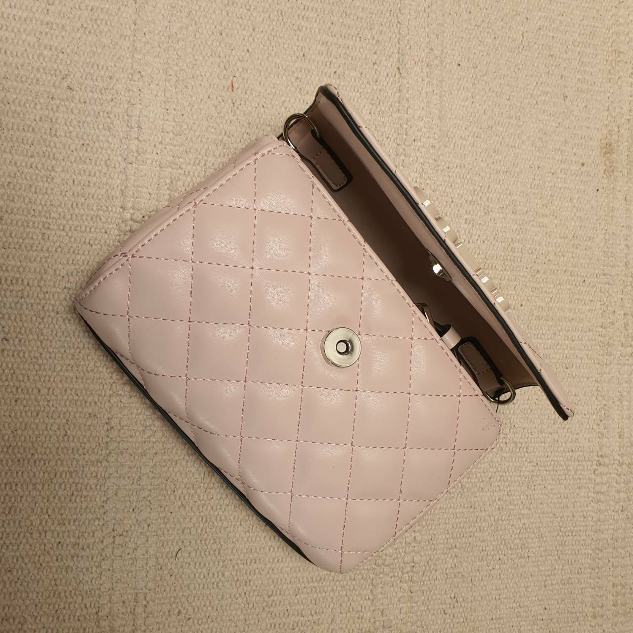 Guess elliana Crossbody Belt Bag รุ่นนี้ได้ทั้งสะพายยาวและคาดเอวค่ะ ด้านหน้าติดโลโก้แบรนด์สีตามหนังกระเป๋า หนังเป็นลายตาราง เปิดปิดด้วยกระดุมแม่เหล็ก ด้านในบุผ้าลายโลโก้แบรนด์ ด้านหลังมีที่สอดสายสำหรับคล้องเอว รุ่นนี้มีสายยาวให้ทั้ง 2 เส้นสำหรับต่างโอกาสค