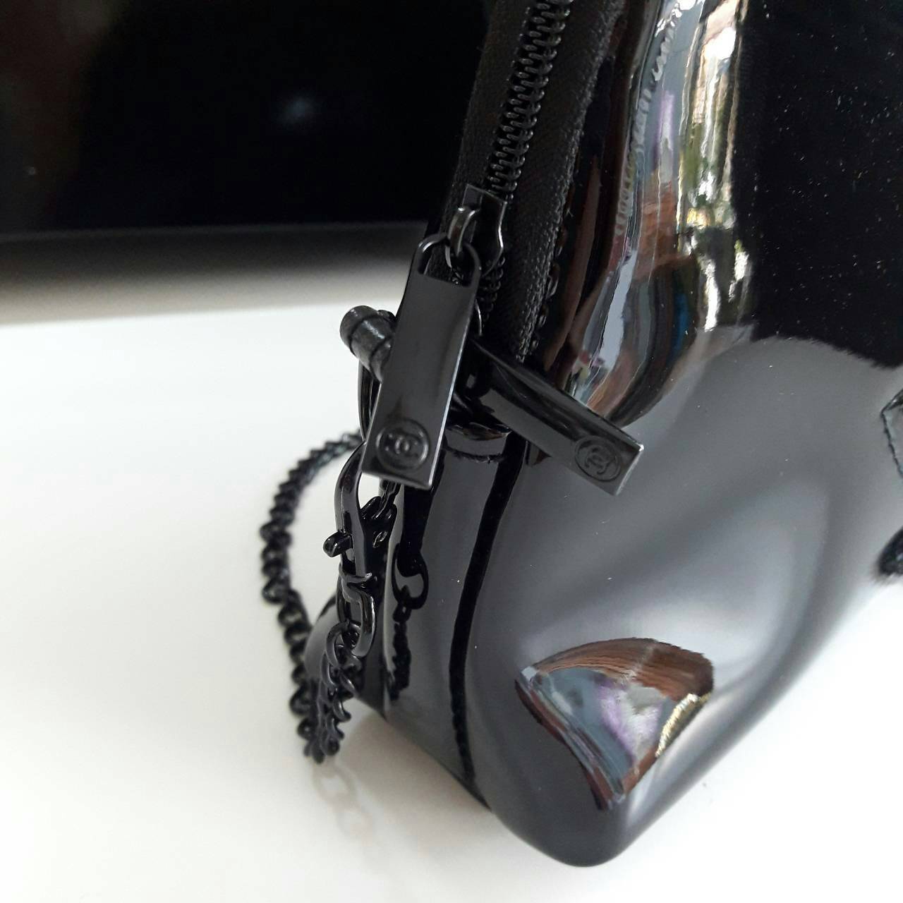 Chanel precision luxury leather clutch with chain จากงานพรีเมี่ยมกิ๊ฟ แบรนด์ดังหนังแก้วมันสวยหรู ด้านหน้า ตกแต่งโลโก้แบรนด์บนเฟอร์สีดำ สายโซ่ยาวสีดำสุดหรู สายถอดเก็บได้ ด้านในบุผ้ามันสีแดง ปั้มแบรนด์แท้ จุของได้เยอะ ใส่มือถือได้ทุกรุ่นไปอีกก จะสะพายหรือถื