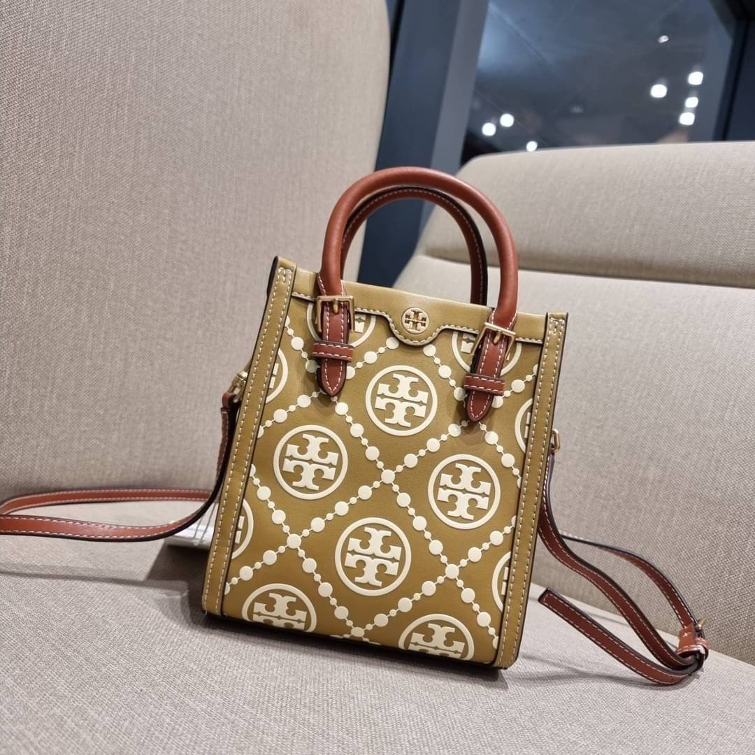 TORY BURCH T MONOGRAM EMBOSSED MINI TOTE สุดหรูกับกระเป๋าสะพายทรงโท้ท ไซส์มินิ ที่สร้างความหรูหราให้ตัวกระเป๋าด้วยดีเทลลายนูน แต่งแต้มลวดลายเอกลักษณ์ สีลูกคุณมากๆ!! วัสดุหนังแท้ ผิวสัมผัสดี ปากกระเป๋ามีแถบแม่เหล็กกันของหล่นได้ ภายในโล่ง ใส่ของจำเป็นได้ โท