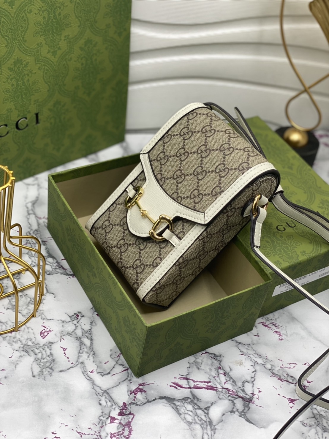 หนังแท้ GUCCI Horsebit phone bag กระเป๋าสะพาย กระเป๋าใส่โทรศัพท์สุดคลาสสิก หนังวัวแท้สีน้ำตาล/สีขาว อะไหล่ทองสวย ดีไซต์สัญลักษณ์วงแหวนตามแบบฉบับแบรนด์ สายสะพายยาวที่สามารถปรับระดับได้ ภาพสินค้าถ่ายจากงานขายจริง ใช้งานต่างประเทศได้ค่ะ