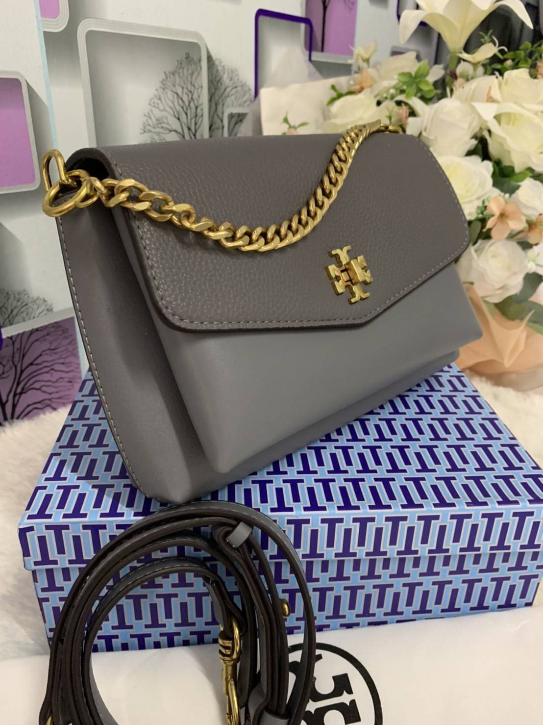 TORY BURCH KIRA MIXED-MATERIALS TOP-HANDLE SATCHEL กระเป๋าสะพายข้าง วัสดุหนังแกะสังเคราะห์ อะไหล่ทอง ด้านหน้าประดับโลโก้แบรนด์ ตกแต่งสายโซ่ห้อยสีทอง (สามารถถอดออกได้) เปิด-ปิดด้วยตัวล็อคหมุน ภายในโล่งกว้าง ซับในบุผ้าลายแบรนด์ แบ่งออกเป็น 3 ช่องใหญ่ พร้อมช