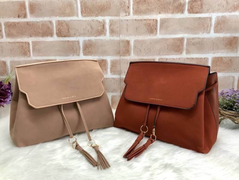 CHARLES & KEITH TASSEL DETAIL SLING BAG กระเป๋าสะพายทรงสวย ที่ฝาพับด้านหน้าแต่งหนังตัดกับหนังกลับสวยงาม สะพายได้ทั้งแบบเป้ และสะพายข้างก็เก๋ไปอีกแบบ มีโซ่เหล็กห่วงห้อยตุ้งติ้งน่ารัก จุของได้เยอะ พร้อมปั๊มโลโก้แบรนด์สีทองเด่น ภายในมีช่องแบ่งใหญ่ใส่ iPhone 