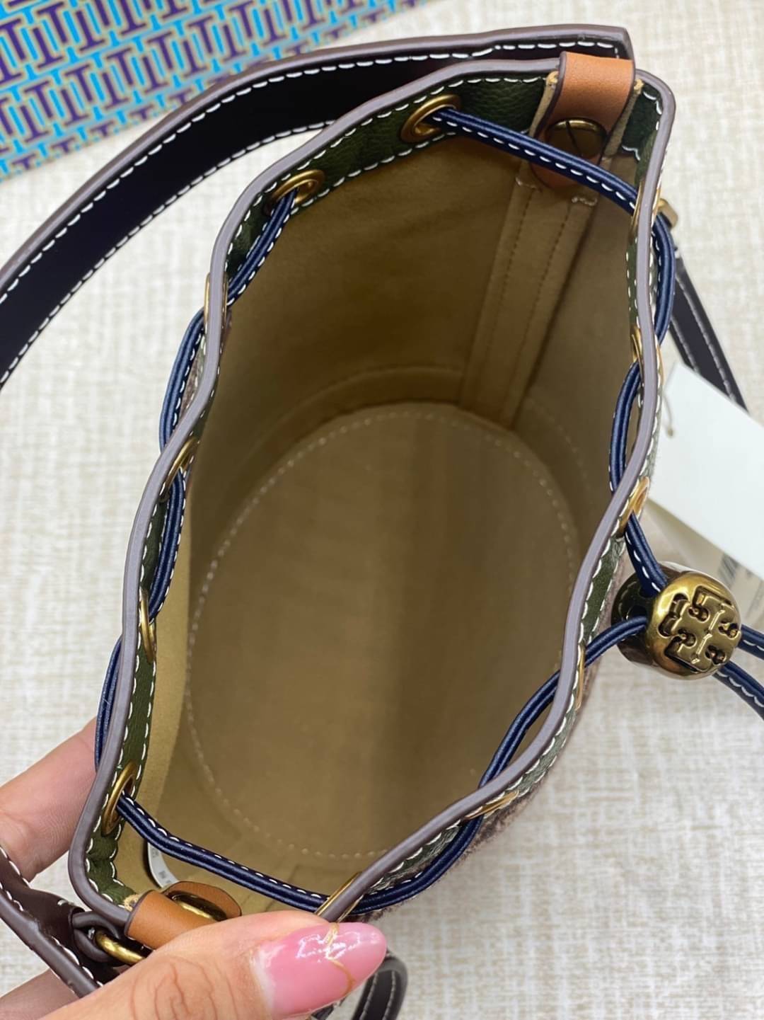 Tory Burch T Monogram Calf Hair Mini Bucket Bag กระเป๋าทรงถังผลิตขึ้นอย่างพิถีพิถันด้วยขนลูกวัวพิมพ์ลาย ตัดแต่งหนังอย่างดี
