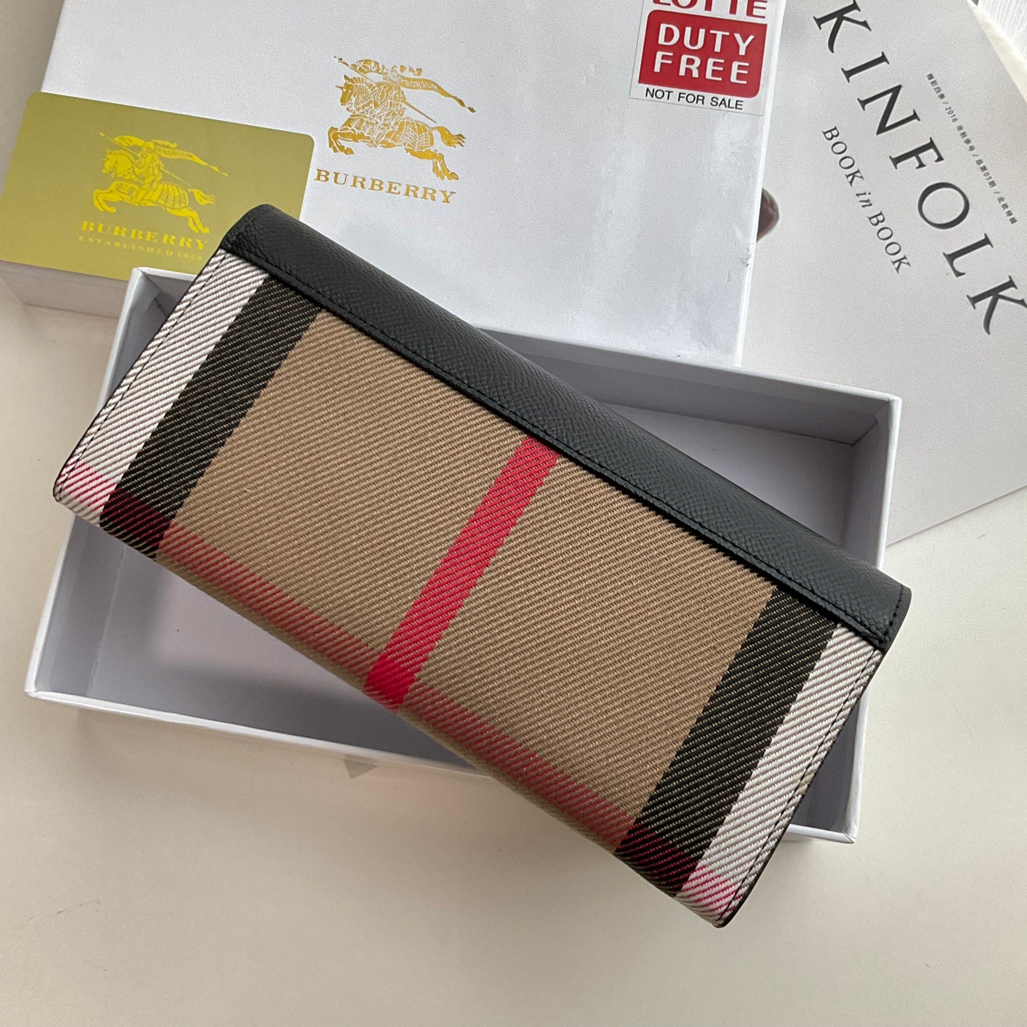 กระเป๋าสตางค์รับทรัพย์ ทรงหรู จากงาพรีเมี่ยมกิ๊ฟ Limited Edition จาก BURBERRY กระเป๋าสตางค์ใบยาวแบบพับกระดุม ทูโทนด้วยหนังแท้คาดผ้าลาย vintage ด้านในมีช่องใส่ธนบัตรยาวทั้งสองฝั่ง ช่องใส่บัตรได้อย่างน้อย 12 ช่อง และช่องเปิดด้วยซิปปั้มแบรนด์อะไหล่ทองสุดหรู 