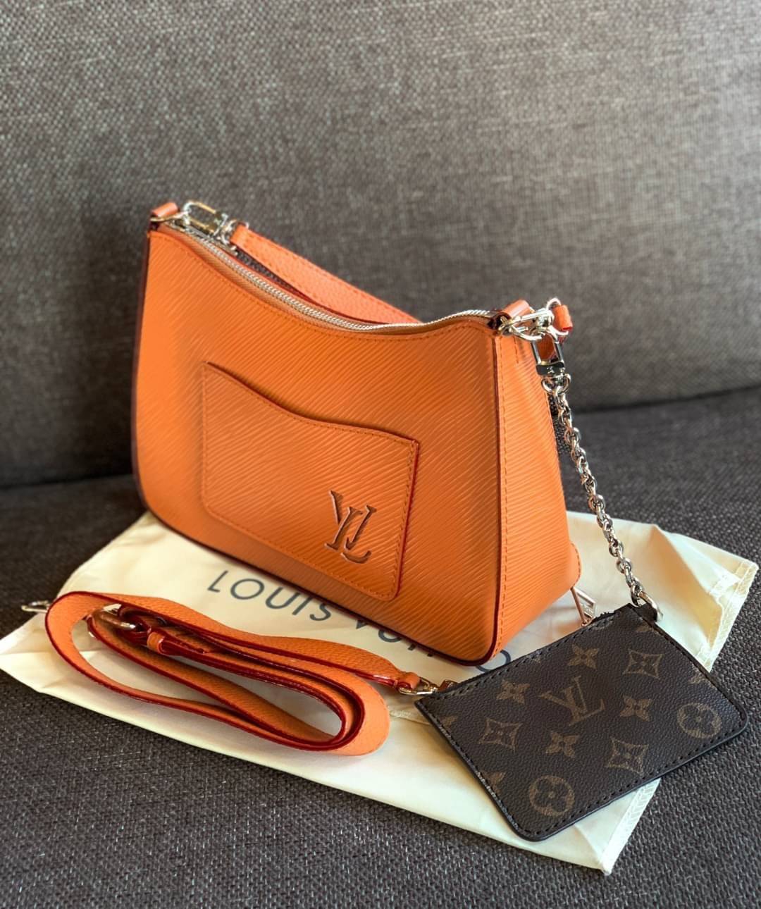 VIP 🥂 LOUIS VUITTON MARELLR EPI LEATHER รุ่นนี้ลายหนังเป็นลายไม้ มีโลโก้แบรนด์แบบฉลุด้านหน้า มาพร้อมกระเป๋าใบลูกแบบซิปจัดเก็บได้ตรงช่องด้านหน้า สามารถถอดออกแยกใช้งานได้ต่างหากนะคะ เปิดปิดกระเป๋าแบบซิป ภายในโล่ง สามารถใส่กระเป๋าเงินใบยาวได้;ของจุกจ