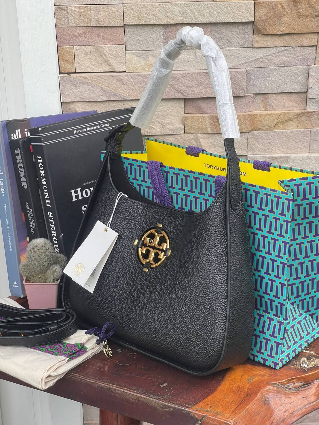Tory Burch Miller Small Classic Shoulder Bag กระเป๋าที่เป็นได้มากกว่ากระเป๋าสะพายไหล่ โดยทางแบรนด์มีการออกแบบที่การต่อสายให้มาในลุคช์สะพายข้างได้ เป็นเอกลักษณ์ไม่ซ้ำใคร รูปทรงคลาสสิค เปิดปิดด้วยแม่เหล็กเพิ่มความปลอดภัย วัสดุหนังวัวแท้นุ่มต่อผิวสัมผัส มาคู