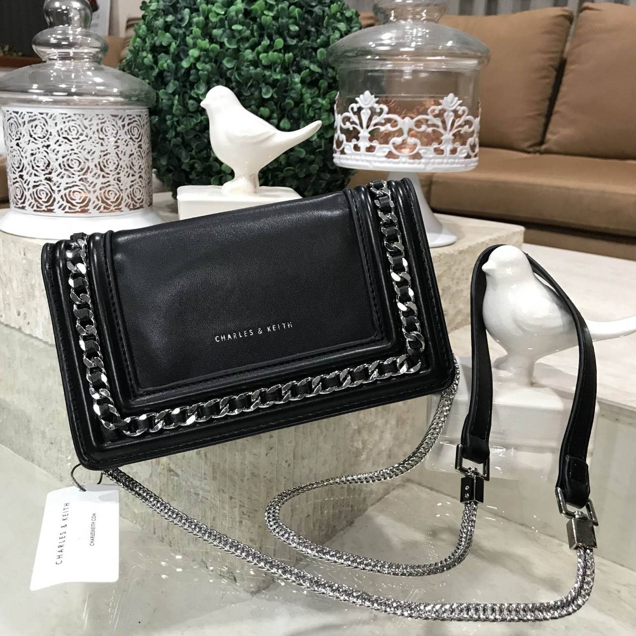 NEW ARRIVAL! CHARLES & KEITH CHAIN DETAIL CROSSBODY BAG กระเป๋าสะพายทรงสี่เหลี่ยมรุ่นชนช็อปขนาดกำลังดีวัสดุหนังนิ่มเรียบประดับด้วยโซ่ด้านหน้าดูมีดีเทล เปิดปิดด้วยกระดุมแม่เหล็ก ภายในมีช่องใส่บัตรและช่องซิป มาพร้อมสายโซ่ต่อหนังถอดถือเป็นคลัชได้ ภาพถ่ายสินค