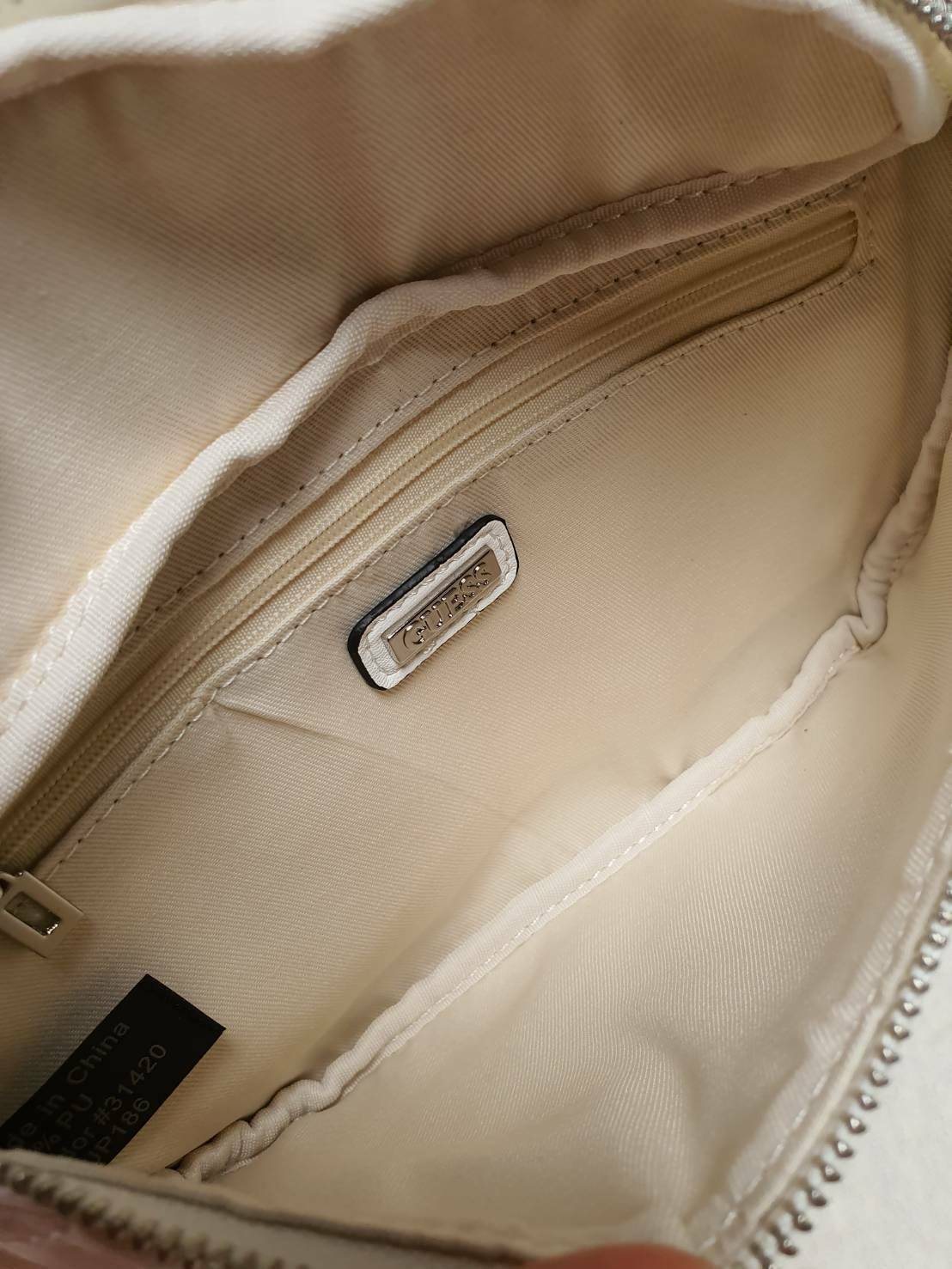 กระเป๋า Guess รุ่นนี้คาดเอว/คาดอก/สะพายข้างได้ครบทุกฟังก์ชั่น ด้านหน้าหนังเป็นลายตาราง ติดโลโก้แบรนด์รูปสามเหลี่ยมด้านหน้า เปิดปิดด้วยซิปยาว ด้านในเป็นช่องกว้างมีช่องซิปด้านใน ตัวกระเป๋าด้านหลังเป็นหนังเรียบ รุ่นนี้มีสายสะพายมา 2 เส้น เส้นแรกเป็นสายหนังปร