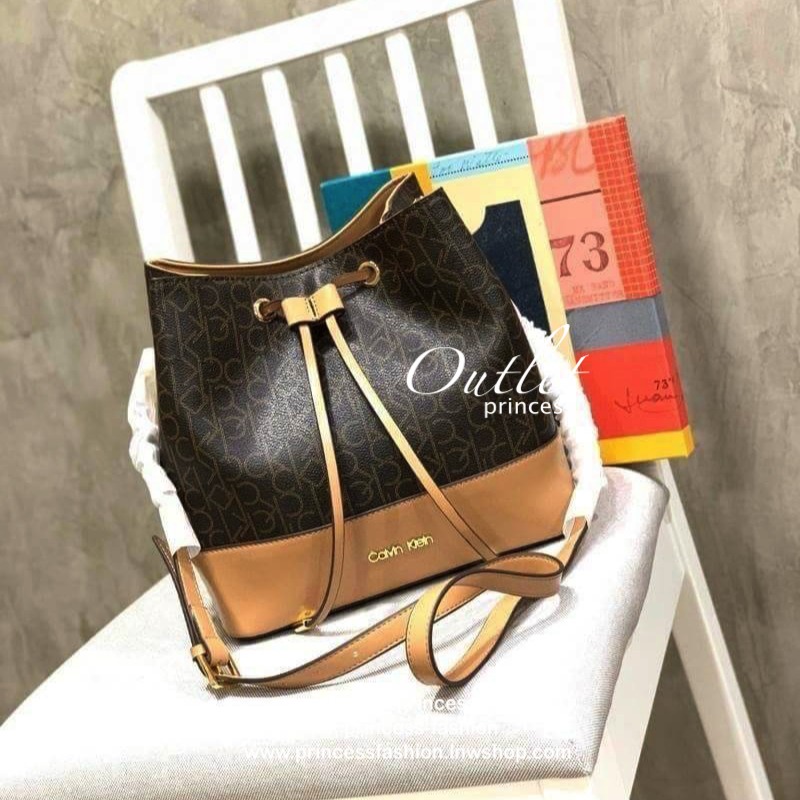 Calvin klein Bucket Logo Bag กระเป๋าสะพายทรงจีบรุ่นใหม่! ฐานกว้างตั้งอยู่ทรง วัสดุpolyester&Pvc เปิดปิดแบบหูรูด ภายในกว้างมีช่องซิปคั่นกลางระหว่างช่องหลัก2ช่อง ทั้งภายในและภายนอกคือลาย Signature แบรนด์ สายสะพายหนังปรับระดับได้ สำหรับสาวๆที่กำลังมองหากระเป