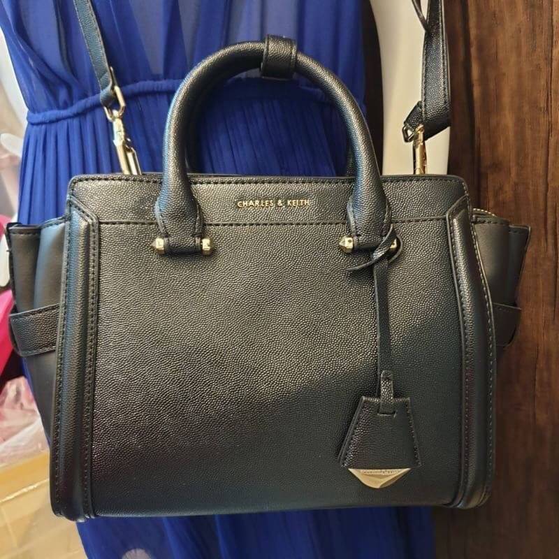 CHARLES & KEITH STRUCTURED TRAPEZE BAG กระเป๋าสะพาย/ถือใบสวย หน้าคาเวียอะไหล่ทอง วางอยู่ทรง มาพร้อมพวงกุญแจหนังห้อย วัสดุด้านหน้า-หลังเป็นลายคาร์เวียร์ ด้านข้างซ้ายขวาหนังเรียบ มีหมุดรองฐาน ด้านหลังมีช่องซิปใส่ของจุกจิก เปิดปิดด้วยซิปบน ด้านในจุของ มีช่อง