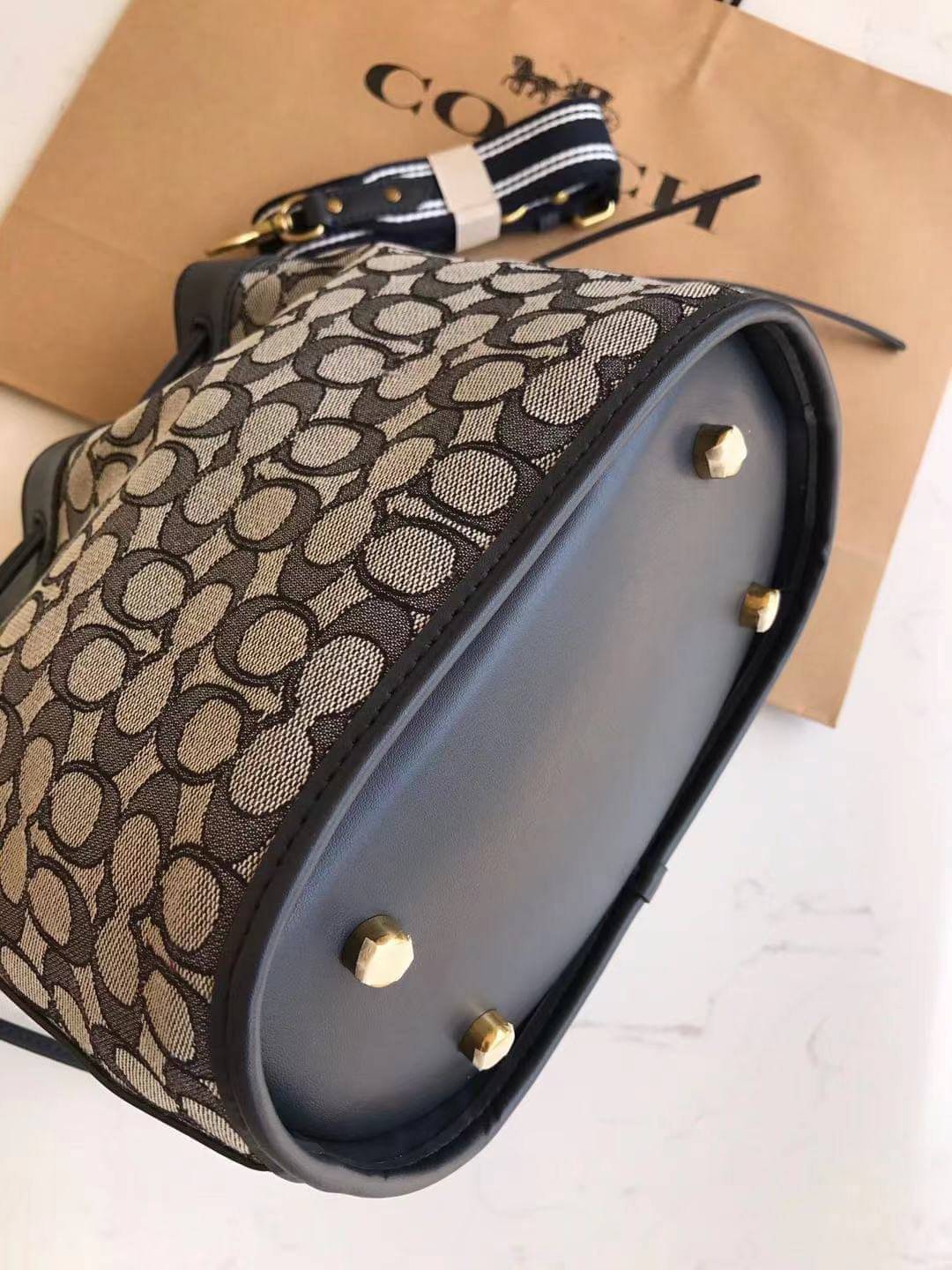 COACH FIELD BUCKET BAG IN SIGNATURE JACQUARD C3853 กระเป๋าสะพายทรงบัคเก็ต รุ่นใหม่ล่าสุด ดีไซน์ลายซิกเนเจอร์บนผ้า jacquard สวยคม เป็นเอกลักษณ์ไม่ซ้ำใคร มาพร้อมสายสะพายผ้าสปอร์ต และสายสั้นสำหรับคล้องแขนได้ สามารถรูดปิดปากกระเป๋าด้วยหนังรอบใบ เพิ่มดีเทลให้ต