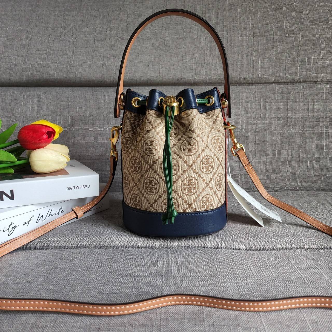 TORY BURCH T MONOGRAM COLORBlOCK JACQUARD MINI BUCKET BAG คอลเลคชั่นใหม่ล่าสุด ครอบครองก่อนใคร รุ่นบัคเก็ตทรงจีบ วัสดุ jacquard สลับหนังแท้ ตัดขอบข้างสีแดงทำให้ดูโดดเด่น หูจับหนังแท้ เปิด ปิด แบบหูรูด ภายในช่องโล่งกว้าง มาพร้อมสายสะพายข้างหนังแท้ ปรับระดั