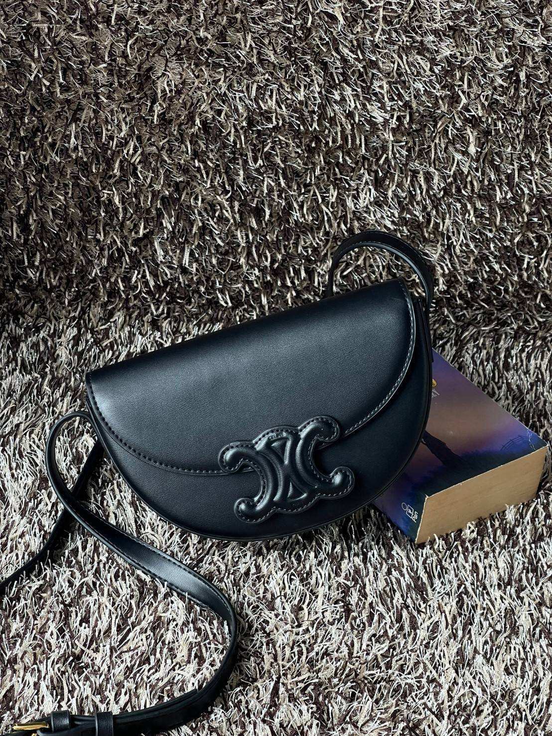 CELINE BESACE CUIR TRIOMPHE IN SMOOTH กระเป๋ารุ่นนี้นำเสนอในรูปทรงฮาล์ฟมูนที่ตอนนี้กำลังงมาแรง เปิดด้วยกระดุมแป๊กเพื่อเผยให้เห็นช่องภายในที่กว้างขวางและกระเป๋าด้านในแบบแบน คุณสมบัติที่โดดเด่นอีกอย่างของกระเป๋าอยู่ที่โลโก้ขนาดใหญ่ รูปทรงสะดุดตา สามารถสะพาย