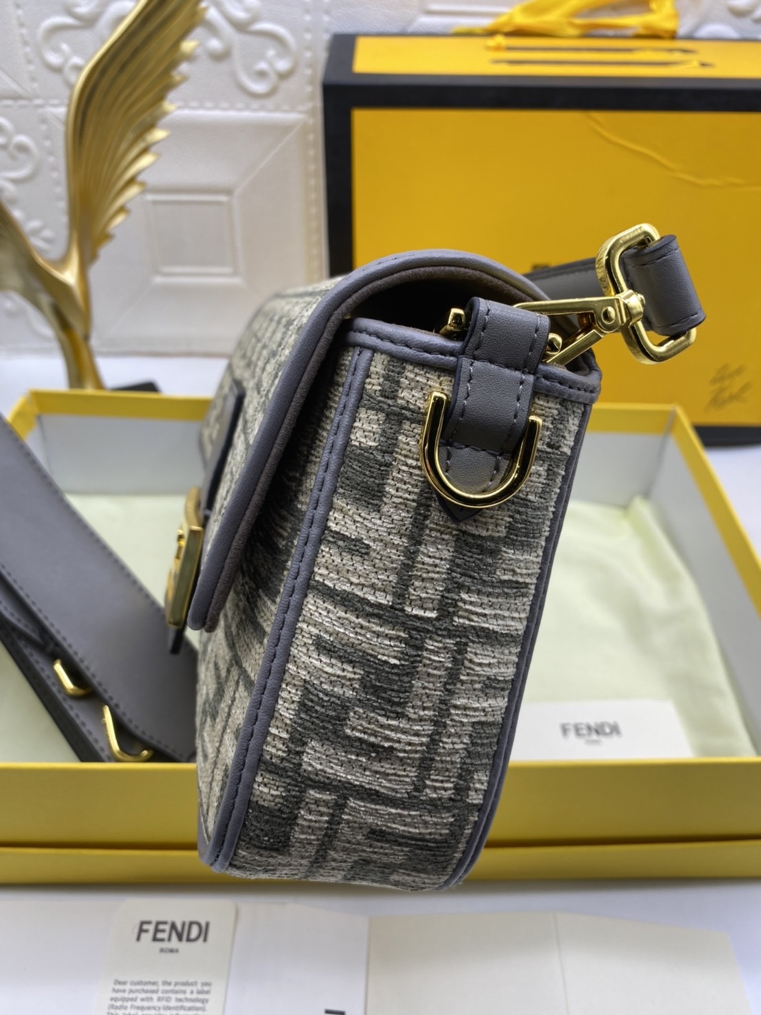 Fendi Baguette FF Tapestry Fabric Bag เกรดออริจินอล กระเป๋าทรง Baguette ขนาดกลาง วัสดุผ้าเซนิล พร้อมลวดลาย FF สีเทาเข้ม ปิดท้ายด้วยรายละเอียดหนังแบบทูโทนและประดับด้วยตัวล็อค FF โดดเด่นด้วยฝาปิดด้านหน้าตัวล็อคแม่เหล็กช่องด้านในบุด้วยผ้าหนังกลับพร้อมกระเป๋า