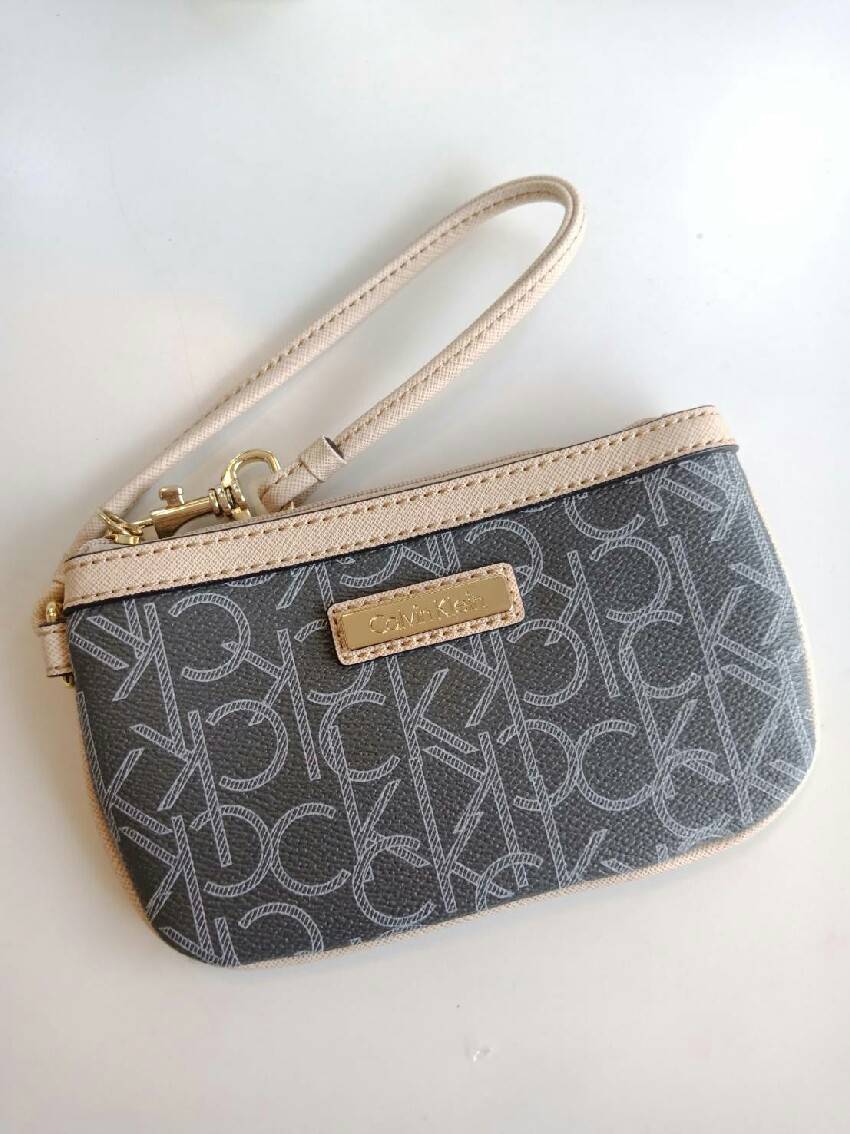 New must have item! กระเป๋าคล้องมือ ทรงน่ารัก จากแบรนด์ calvin klein มีมาให้ช้อปคะ หนัง pvc ทั้งใบอย่างดี มีสายคล้องมือเก๋ ด้านหน้าตกแต่งด้วยโลหะปั้มแบรนด์ เปิดปิดด้วยซิป ด้านในบุด้วยผ้าปั้มแบรนด์ มีช่องใส่บัตรแยก จะใส่ธนบัตรหรือบัตร ก็พกติดตัวในวันสบายๆ