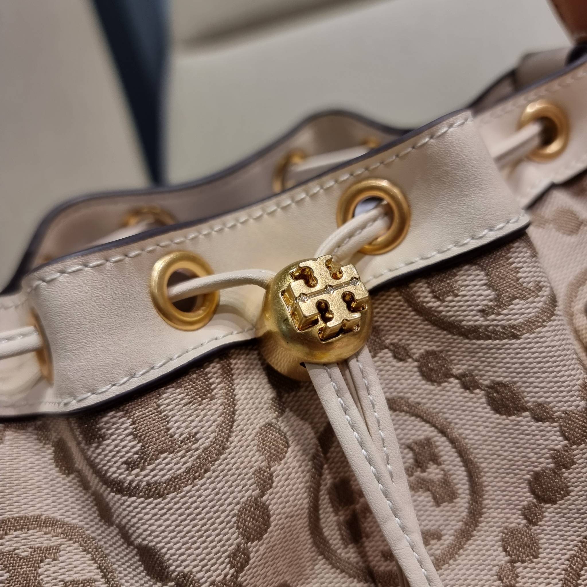 TORY BURCH T MONOGRAM FLORAL BUCKET BAG คอลเลคชั่นใหม่ พร้อมเสิร์ฟความสวยให้ถึงบ้าน!! กระเป๋าบัคเก็ตทรงยอดนิยม ดีไซน์ใหม่ล่าสุด สไตล์งานคราฟ มีลูกเล่นประดับดอกไม้กับตัวกระเป๋า และตัวรูดสาย วัสดุผ้า jacquard ตัดสลับหนังแท้ หูจับและขอบกระเป๋าตกแต่งลายสานสวย