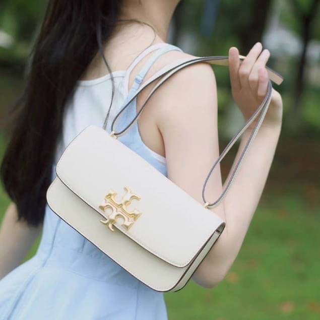 TORY BURCH ELEANOR SMALL LONG CONVERTIBLE SHOULDER กระเป๋าสะพายทรงยาว E/W Eleanor Convertible สูดหรู ดูแพง หนังแท้ เรียบสวยหรู โดดเด่นด้วยป้ายโลโก้สีทอง ลาย Double T อันเป็นเอกลักษณ์ ภายในช่องโล่งกว้างสามารถใส่โทรศัพท์ได้ทุกรุ่น สามารถใส่กระเป๋าสตางค์ใบยา