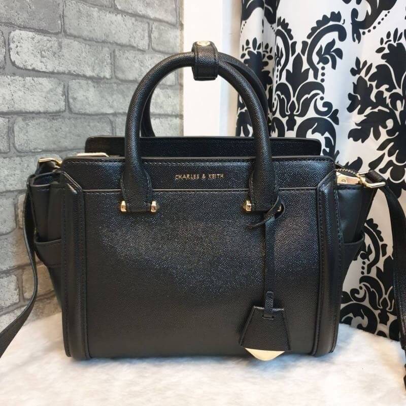 CHARLES & KEITH STRUCTURED TRAPEZE BAG กระเป๋าสะพาย/ถือใบสวย หน้าคาเวียอะไหล่ทอง วางอยู่ทรง มาพร้อมพวงกุญแจหนังห้อย วัสดุด้านหน้า-หลังเป็นลายคาร์เวียร์ ด้านข้างซ้ายขวาหนังเรียบ มีหมุดรองฐาน ด้านหลังมีช่องซิปใส่ของจุกจิก เปิดปิดด้วยซิปบน ด้านในจุของ มีช่อง